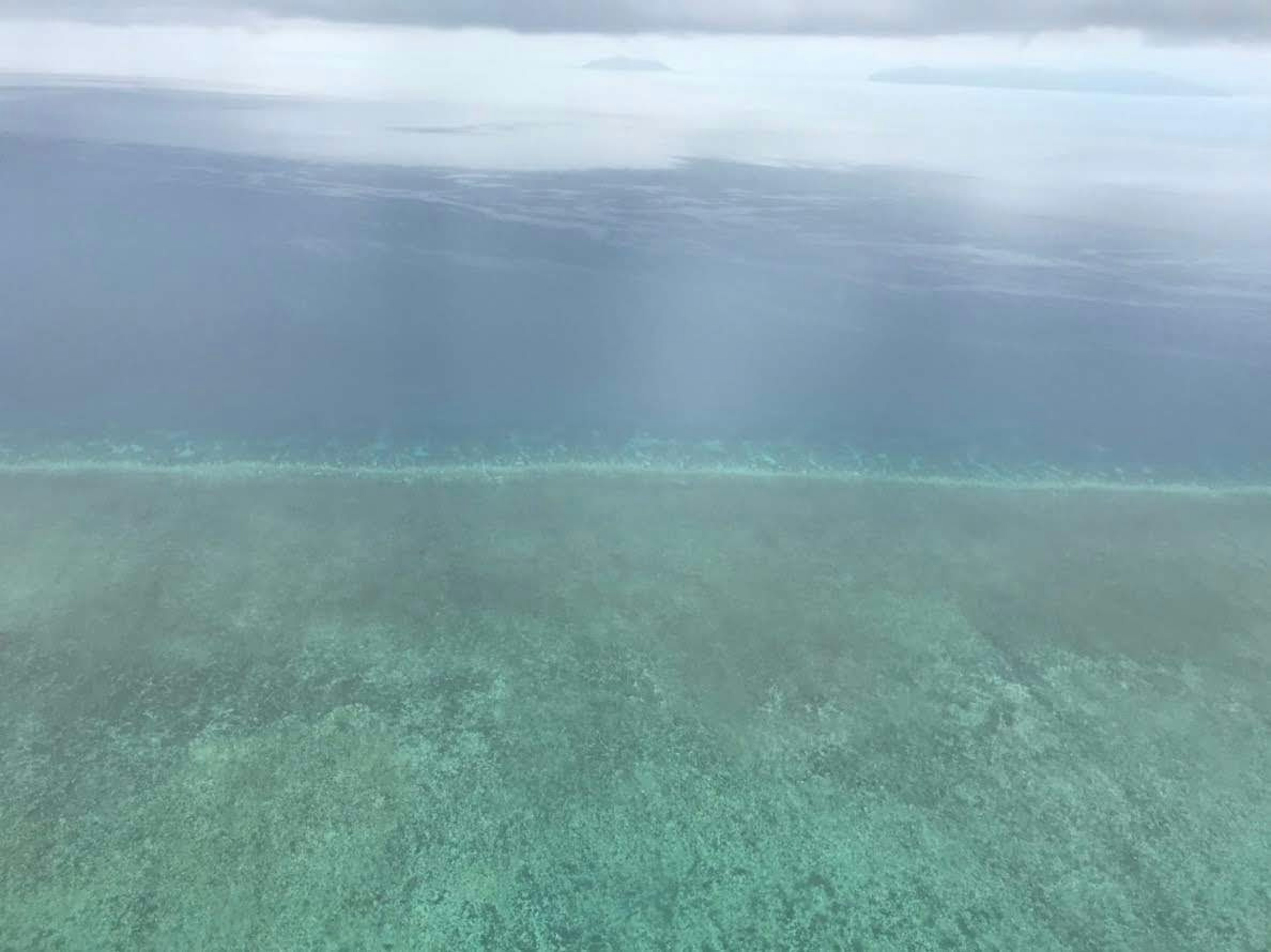 Aerial view of turquoise water and coral reef