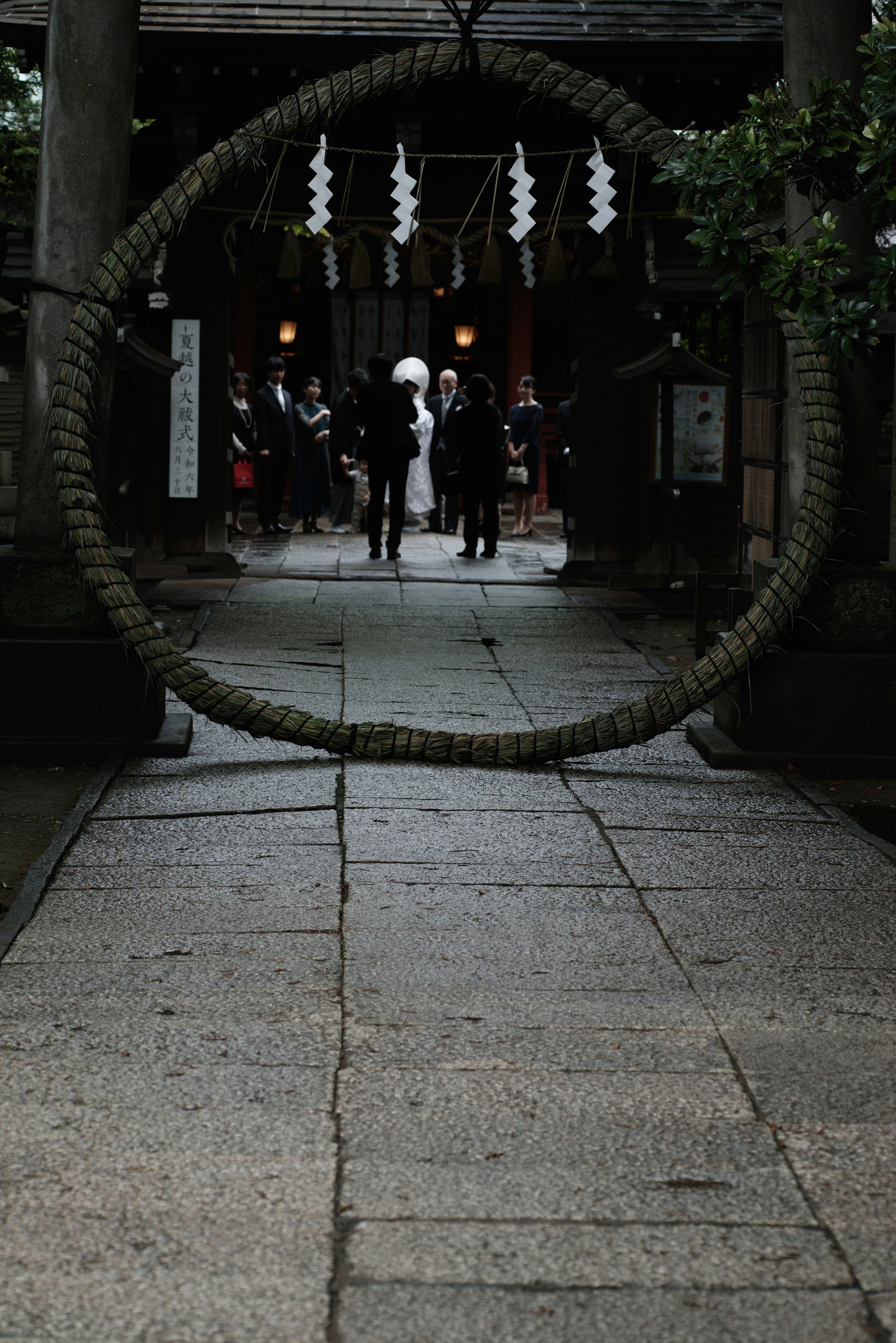 People passing through a large ring in front of a shrine