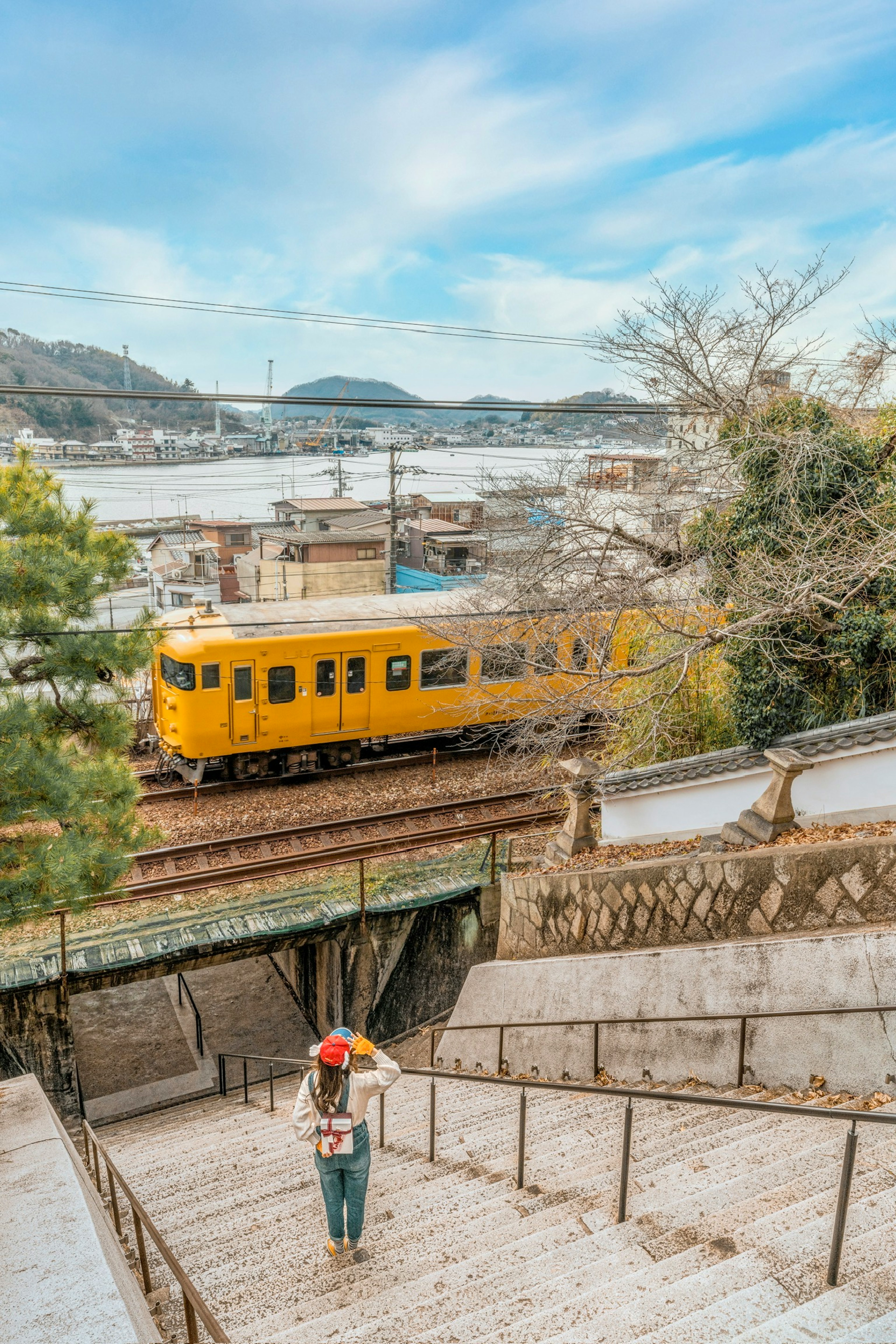 คนเดินลงบันไดพร้อมกับรถไฟสีเหลืองที่วิ่งผ่าน