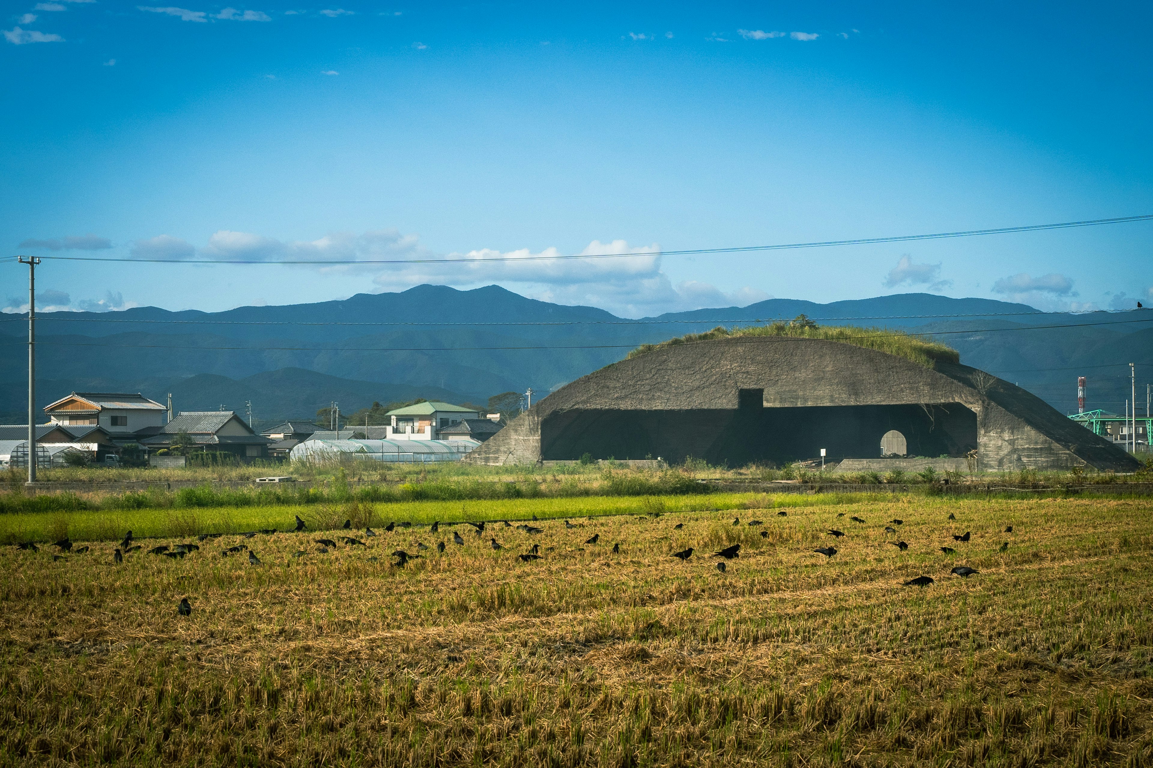 Tumulus ancien près des rizières avec des montagnes en arrière-plan