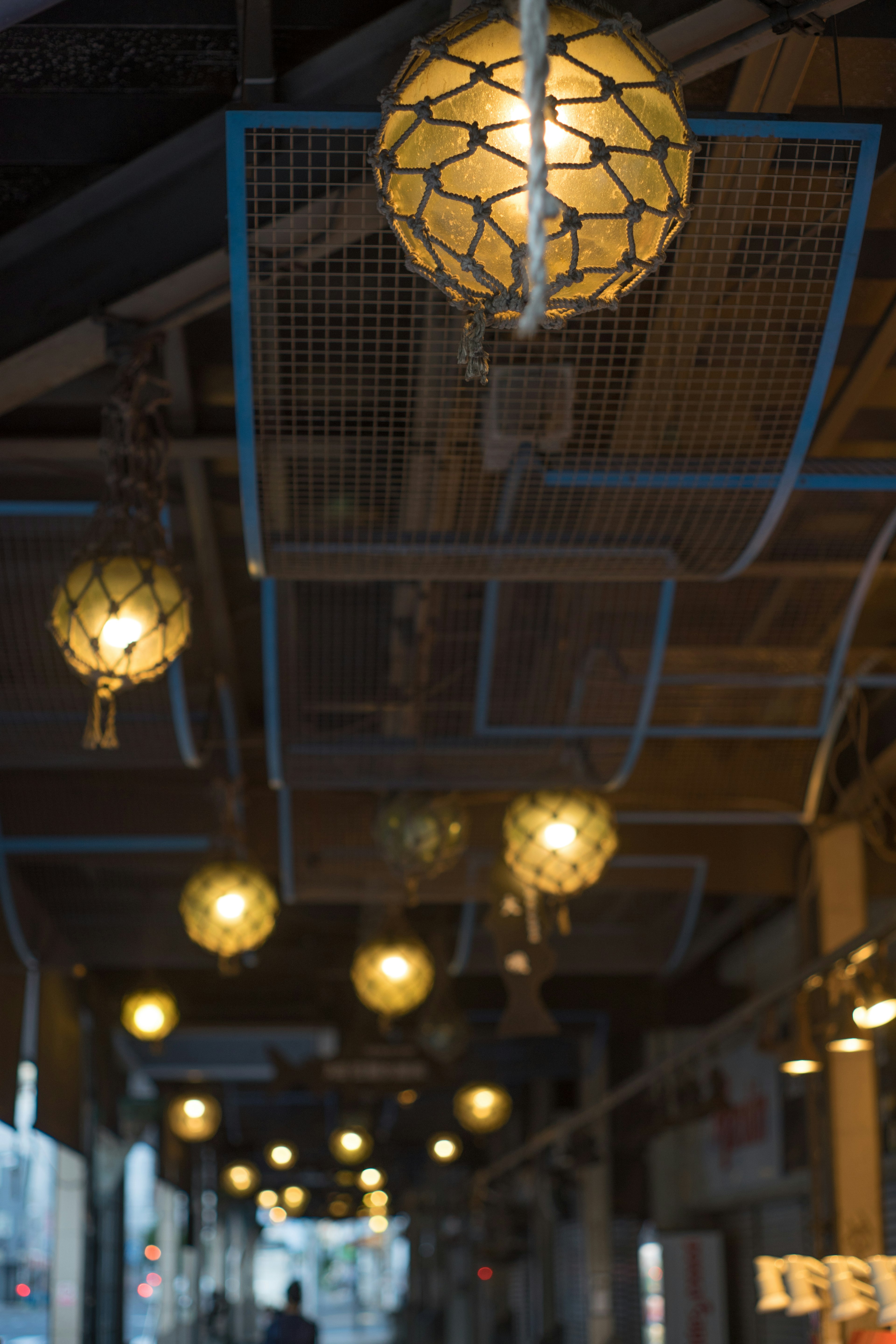 Couloir intérieur avec des lampes rondes suspendues à une structure bleue