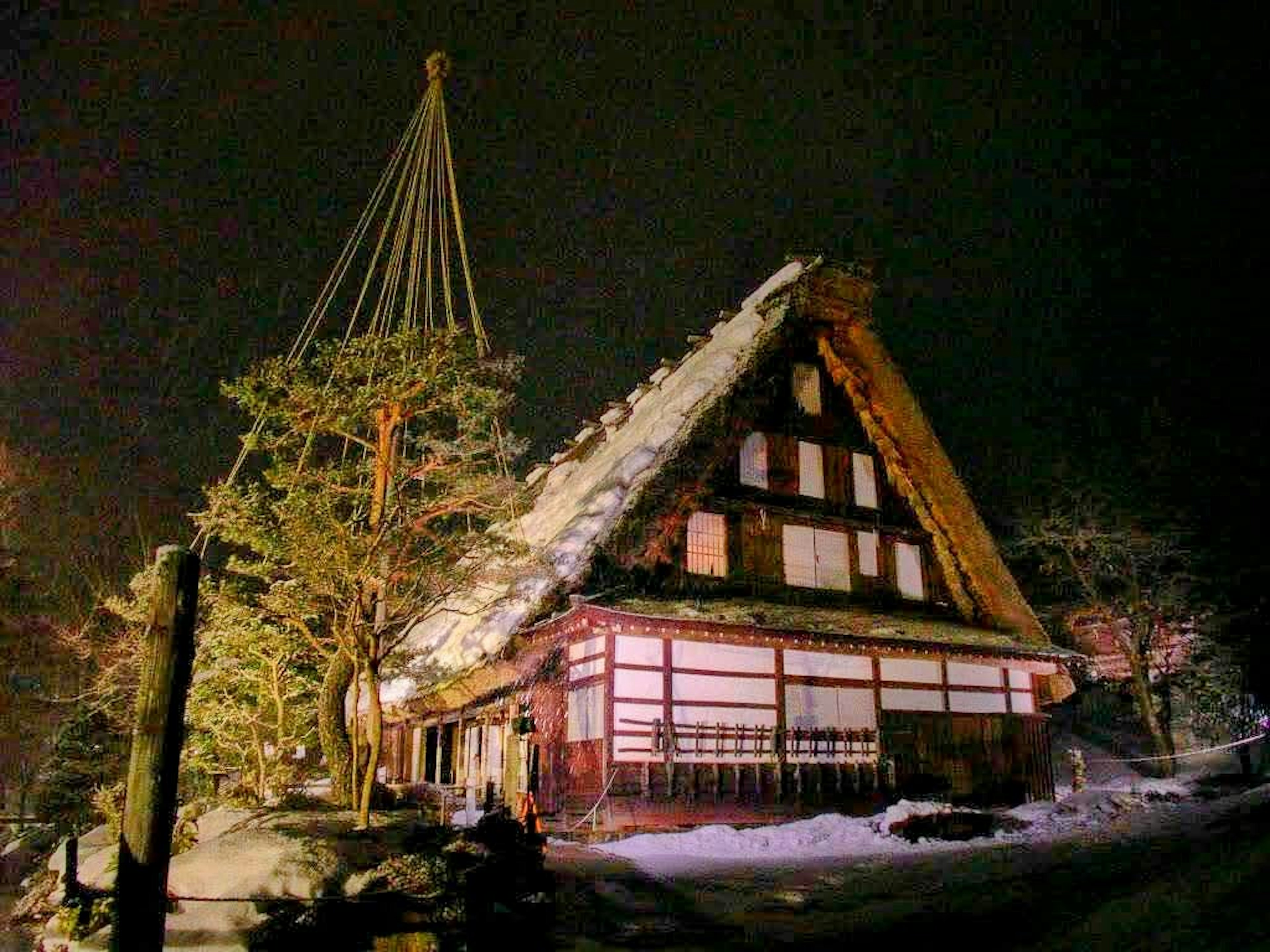 Casa tradizionale gassho-zukuri coperta di neve illuminata di notte