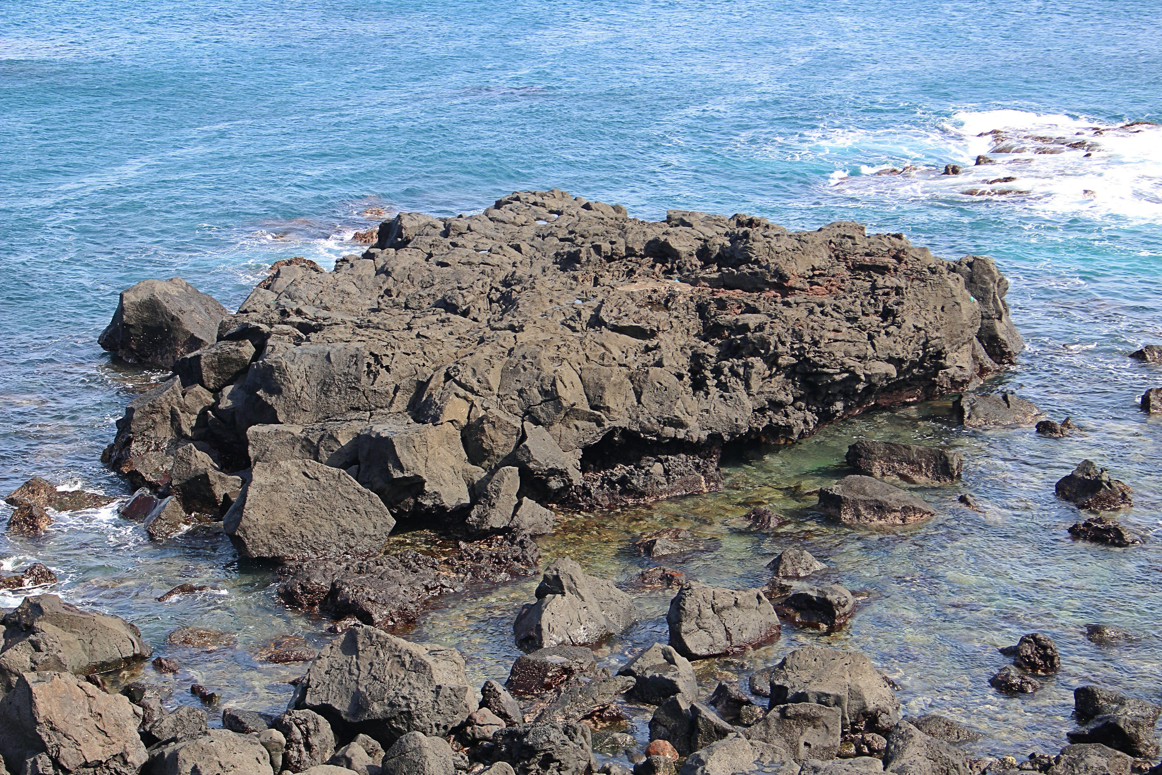 Cluster of rocks in the ocean with clear blue water