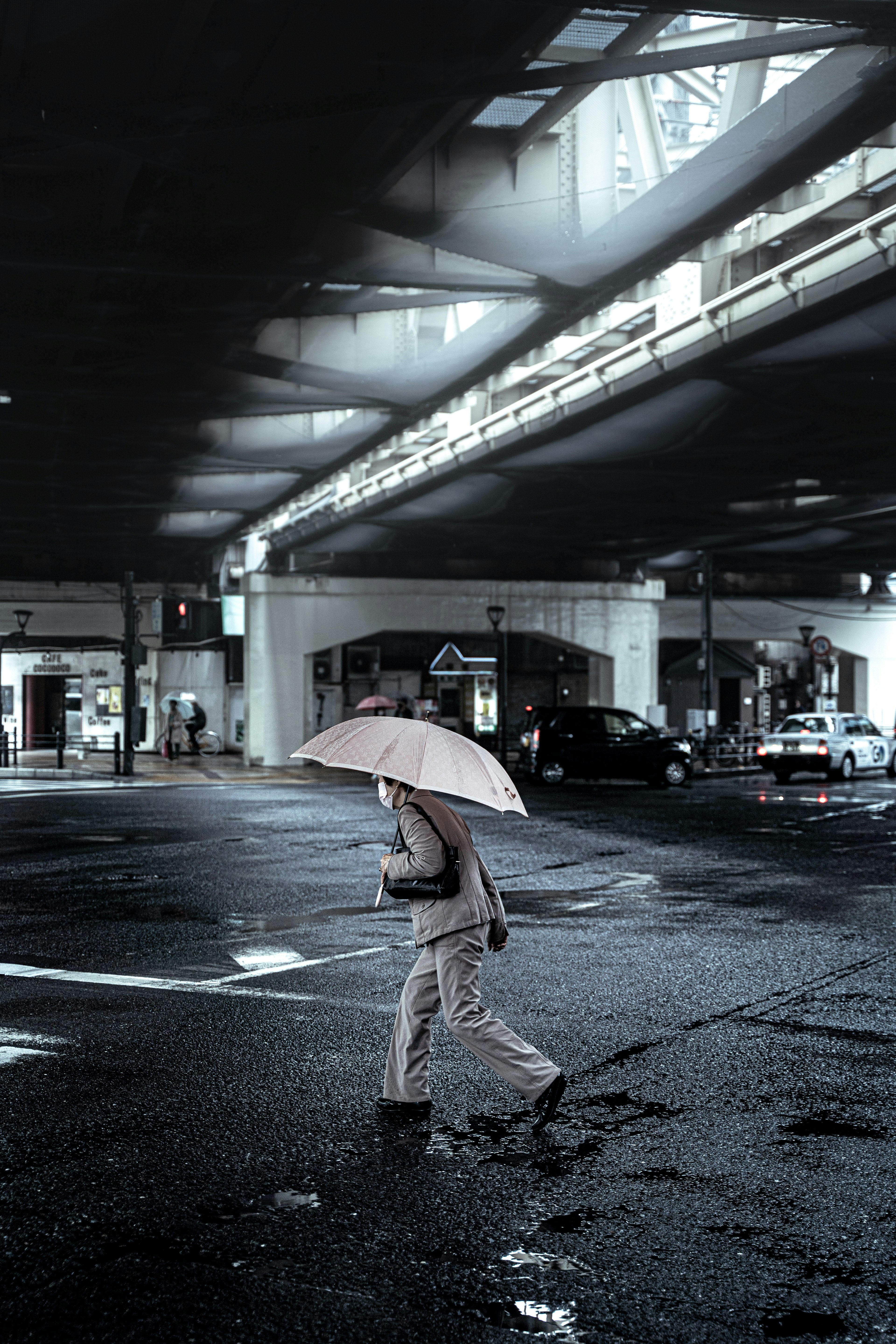 雨傘を持った人が交差点を歩いている都会の風景