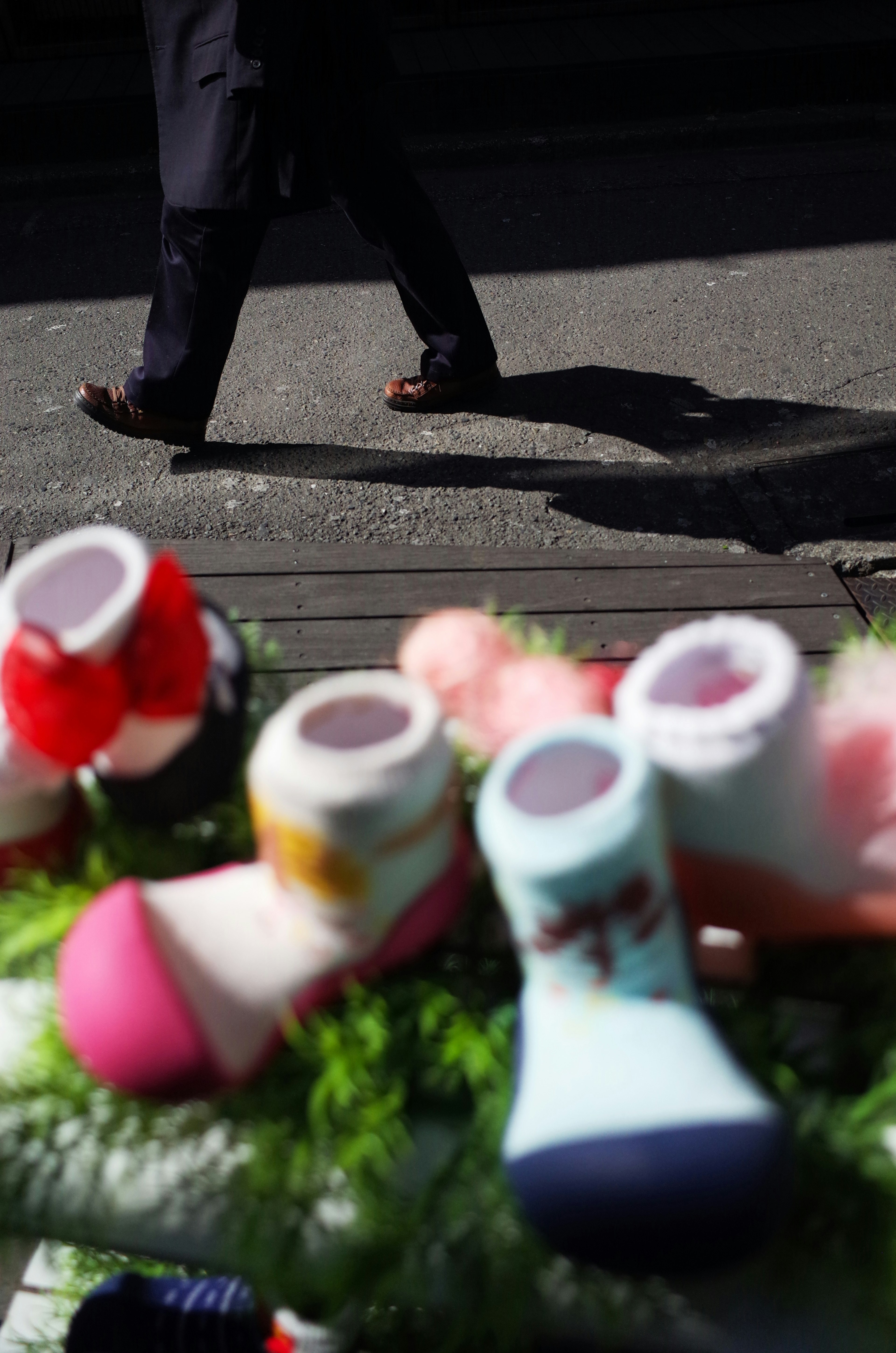 Chaussettes colorées au premier plan avec l'ombre d'une personne marchant