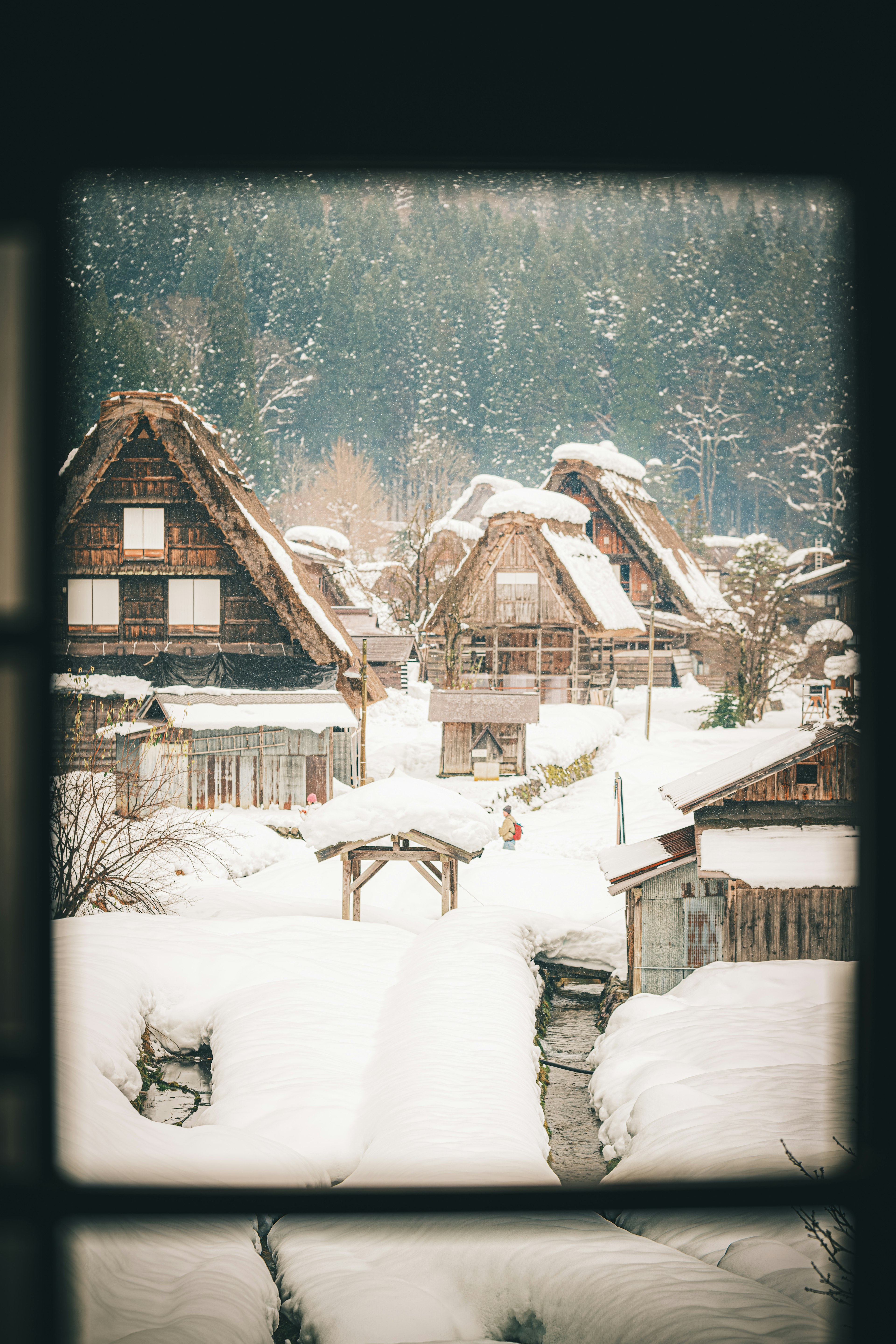 Snow-covered traditional gassho-zukuri houses in a scenic landscape