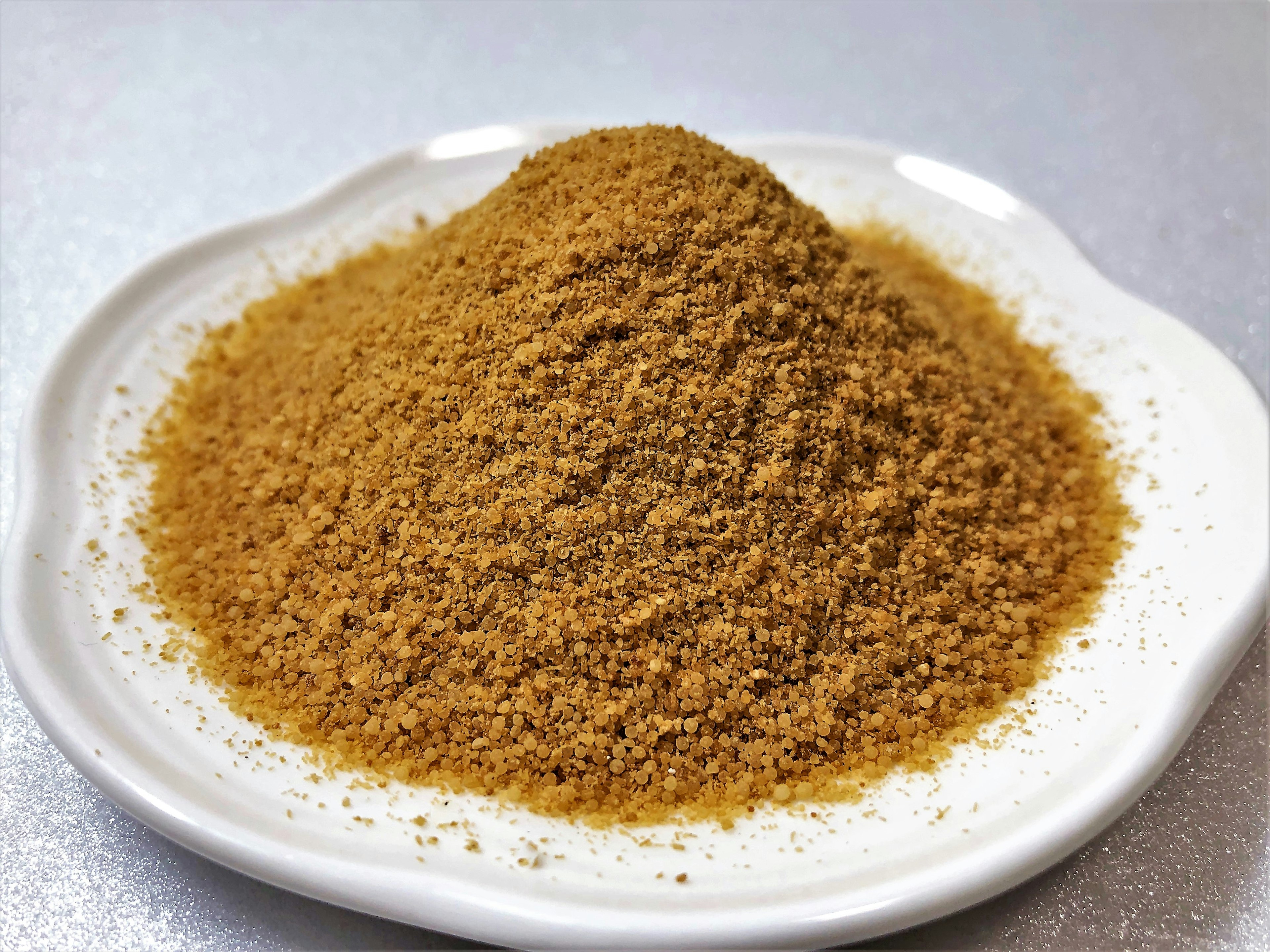 Mound of brown spice on a white plate