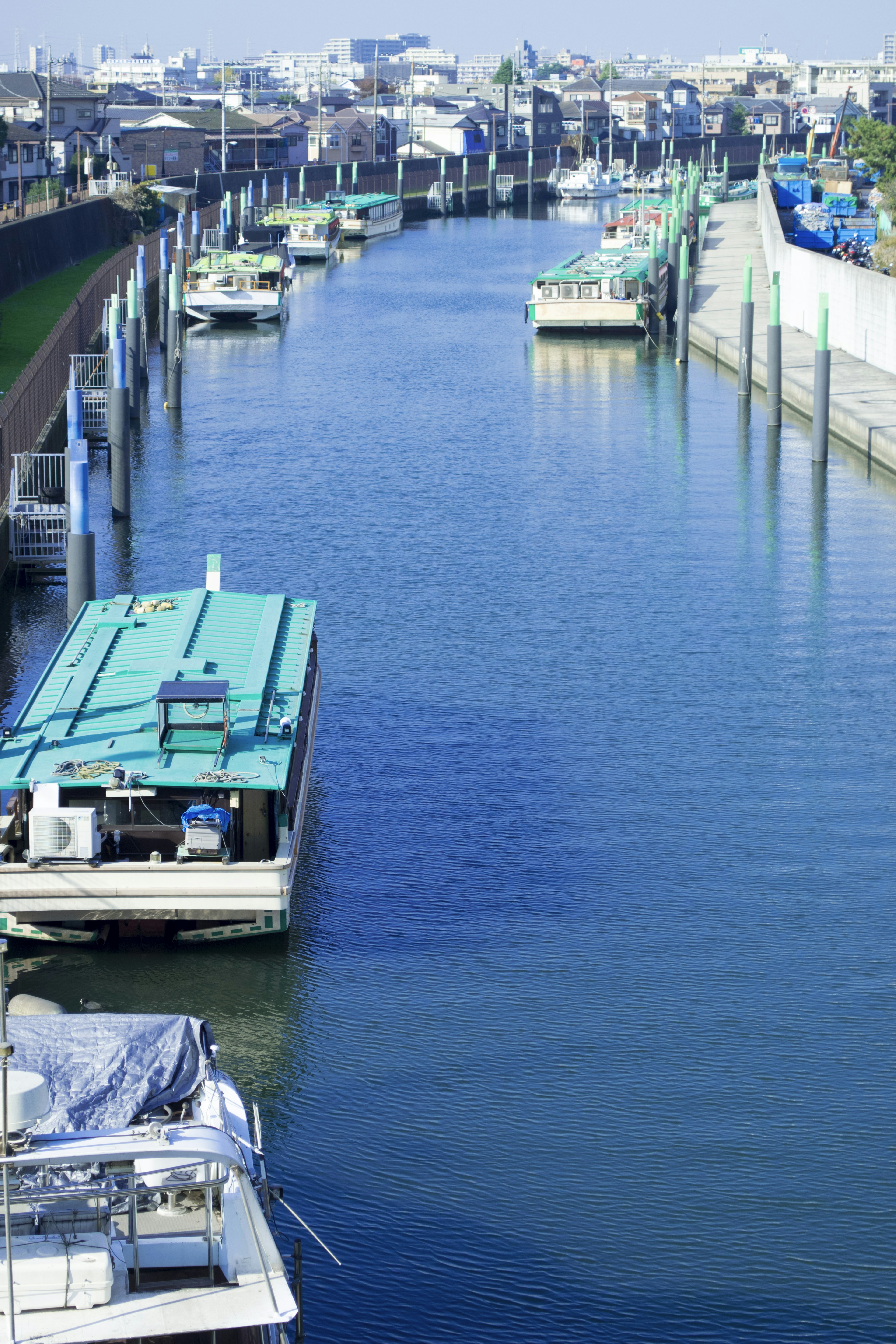 Barcos atracados en un canal azul con un paisaje sereno