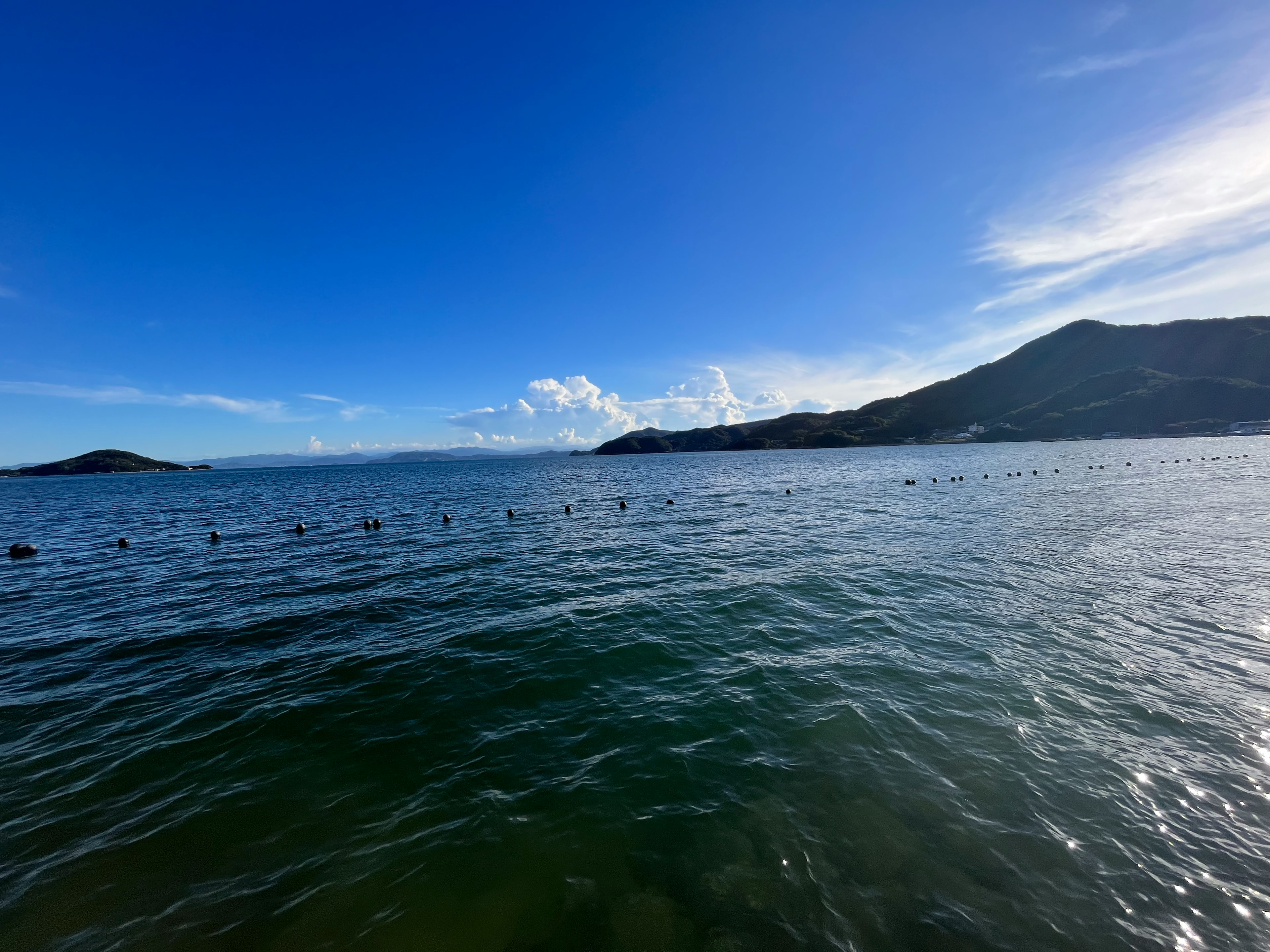 ทิวทัศน์สวยงามของท้องฟ้าสีฟ้าและน้ำที่มีก mountains และเมฆ