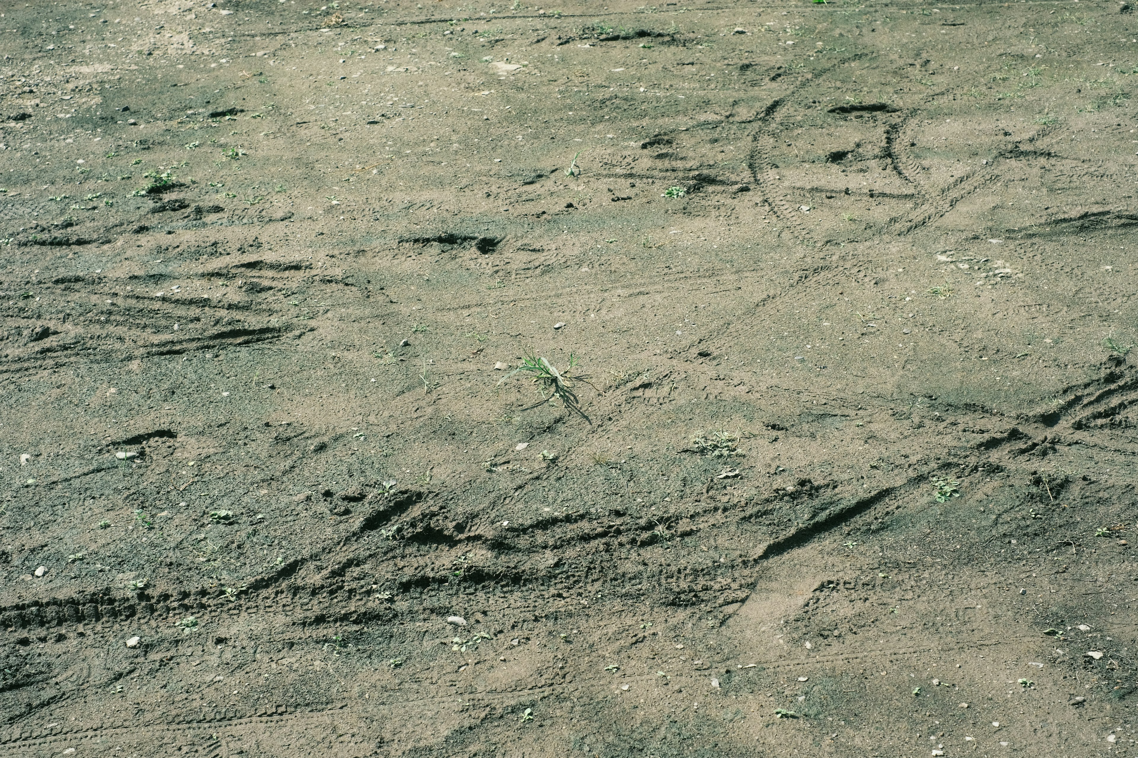 Tire tracks and irregular patterns on gravel ground