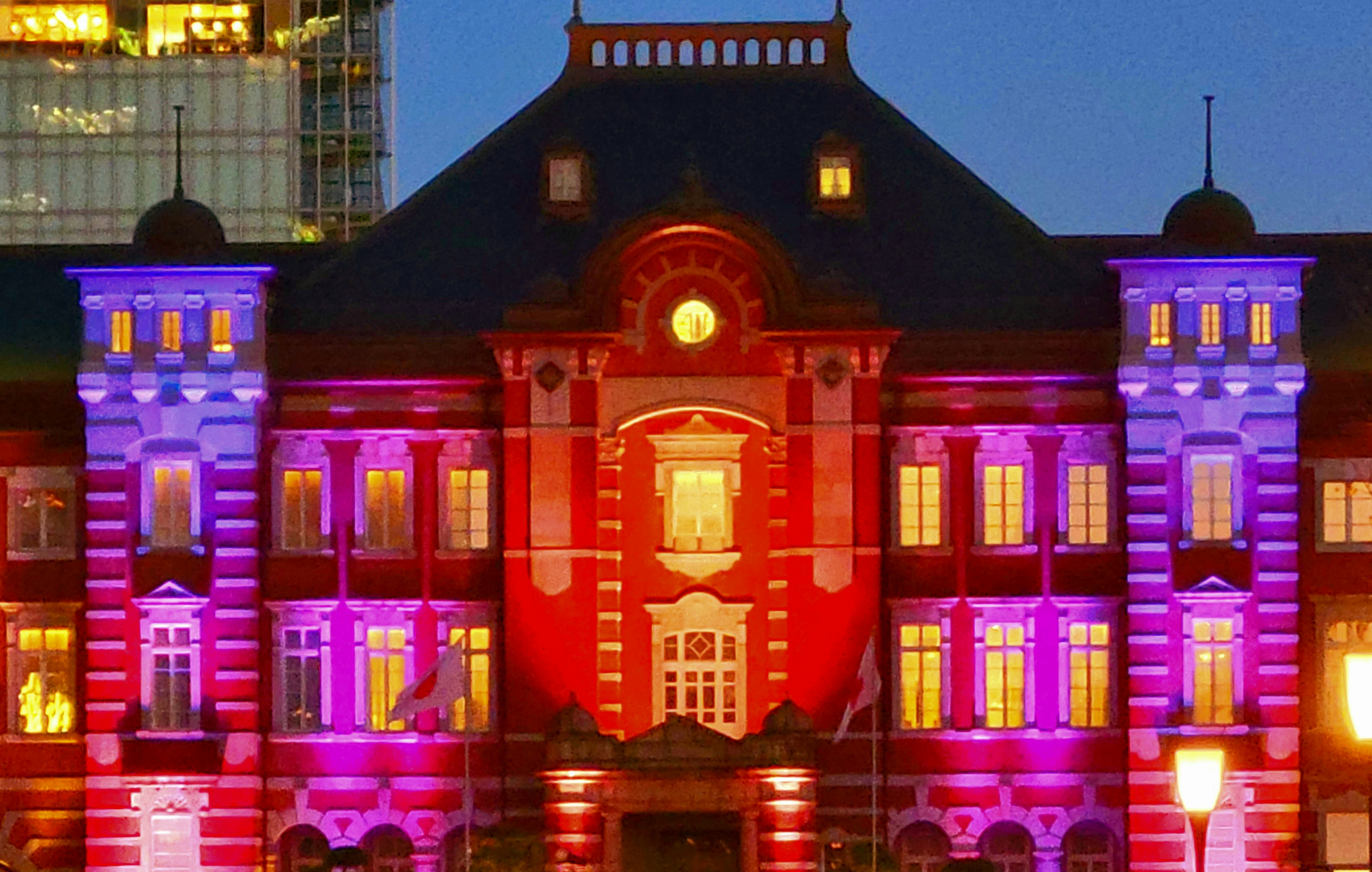 Magnifica illuminazione notturna della stazione di Tokyo con tonalità rosse e viola