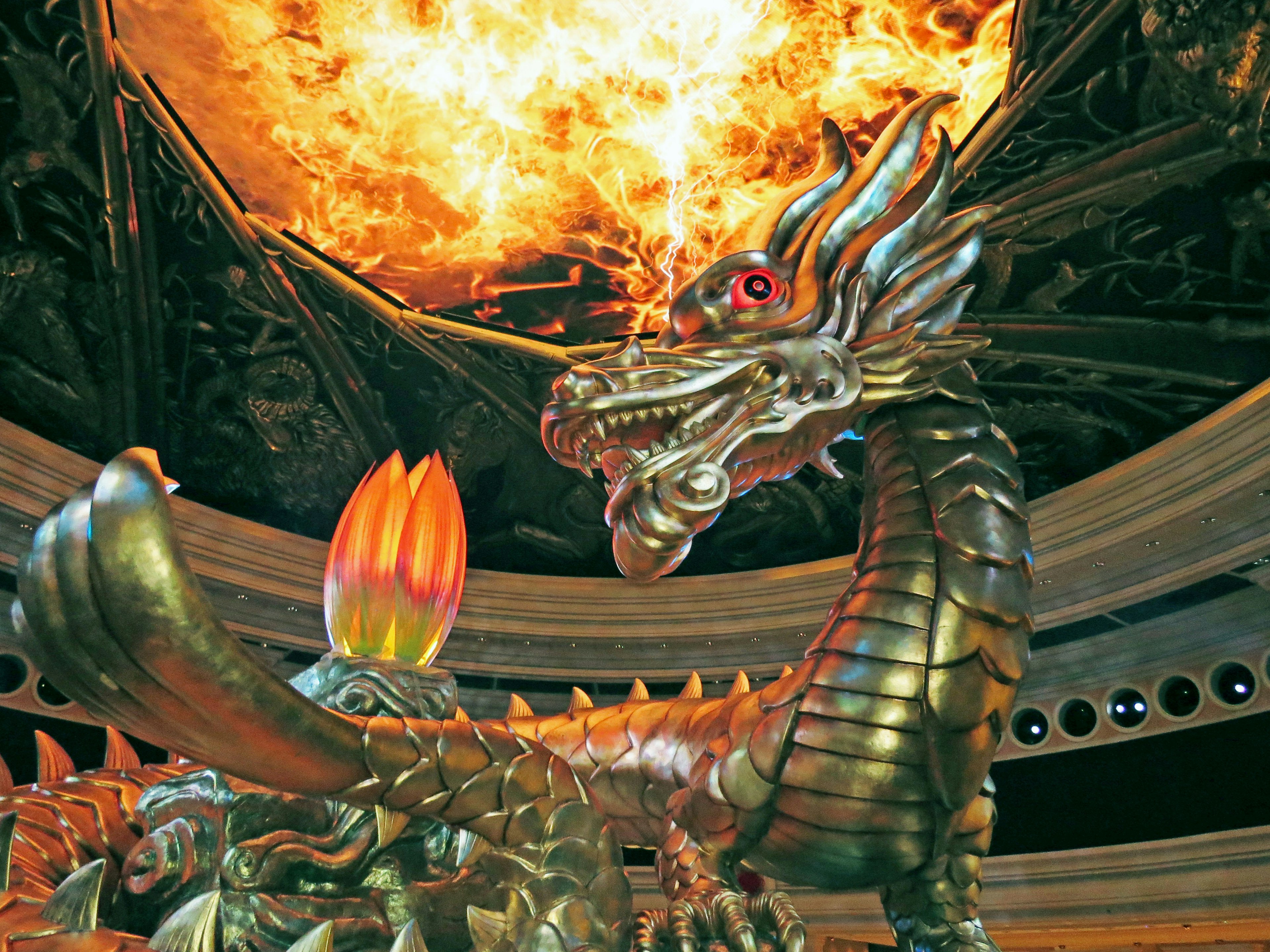 Golden dragon sculpture against a fiery background