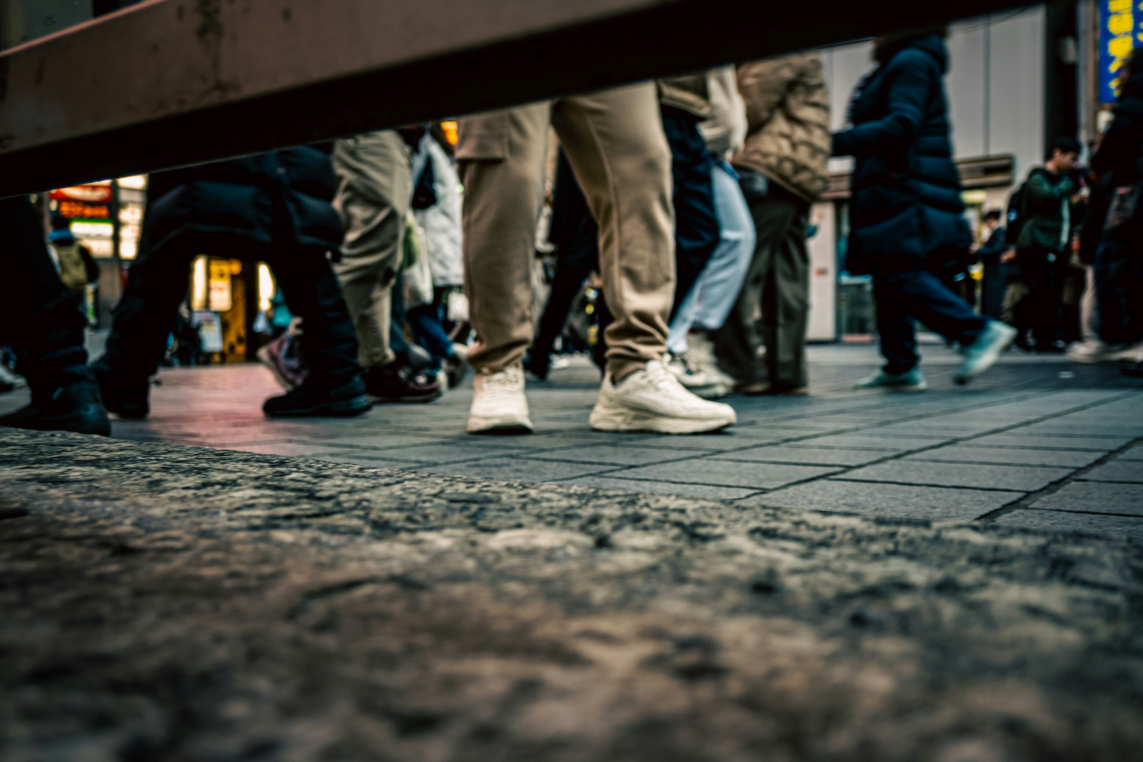 View from below of people walking in a crosswalk prominent white sneakers