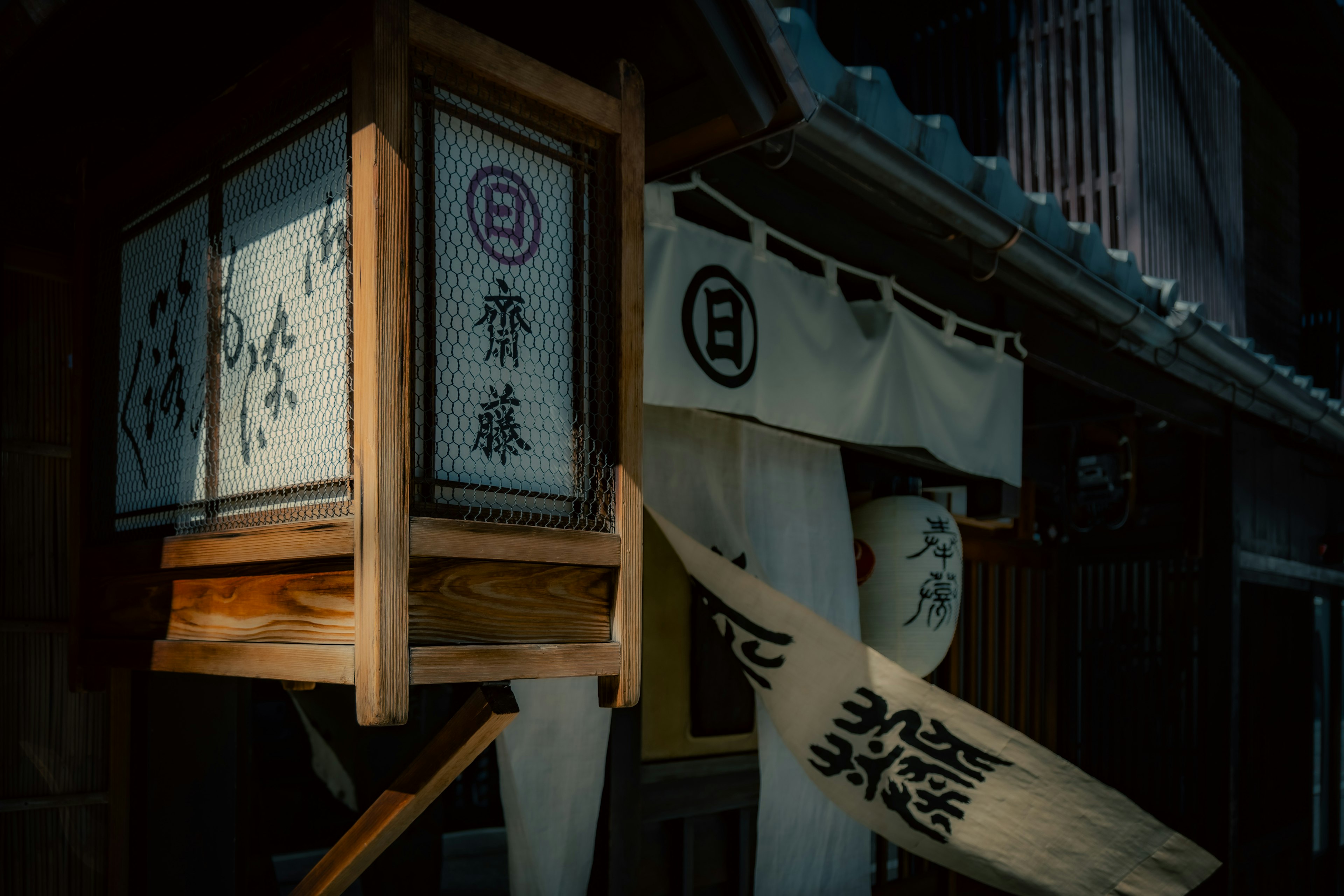 Äußere eines traditionellen japanischen Gebäudes mit Holzlaterne und dekorativem Schild