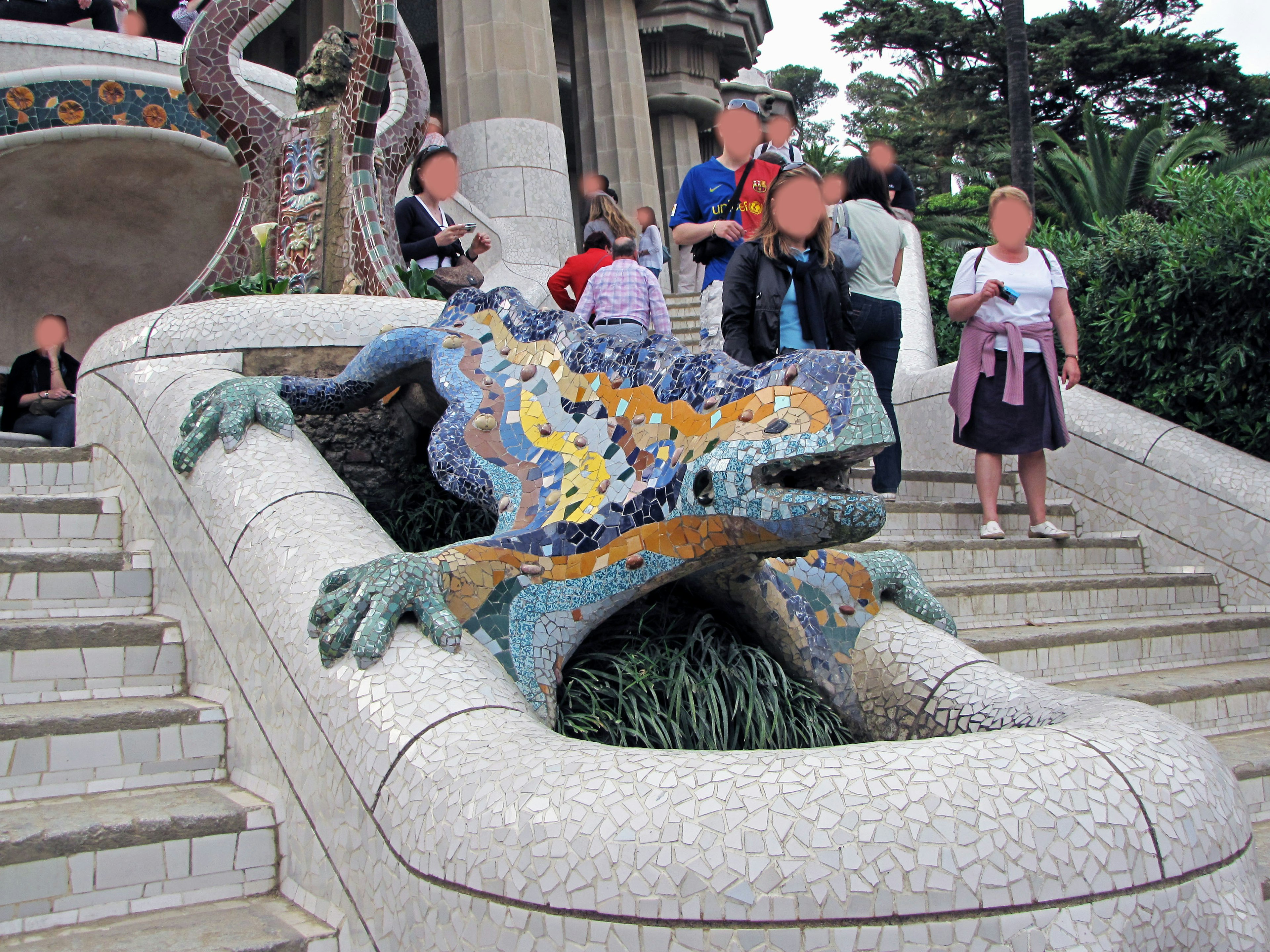 Scultura di lucertola colorata al Parco Güell con turisti