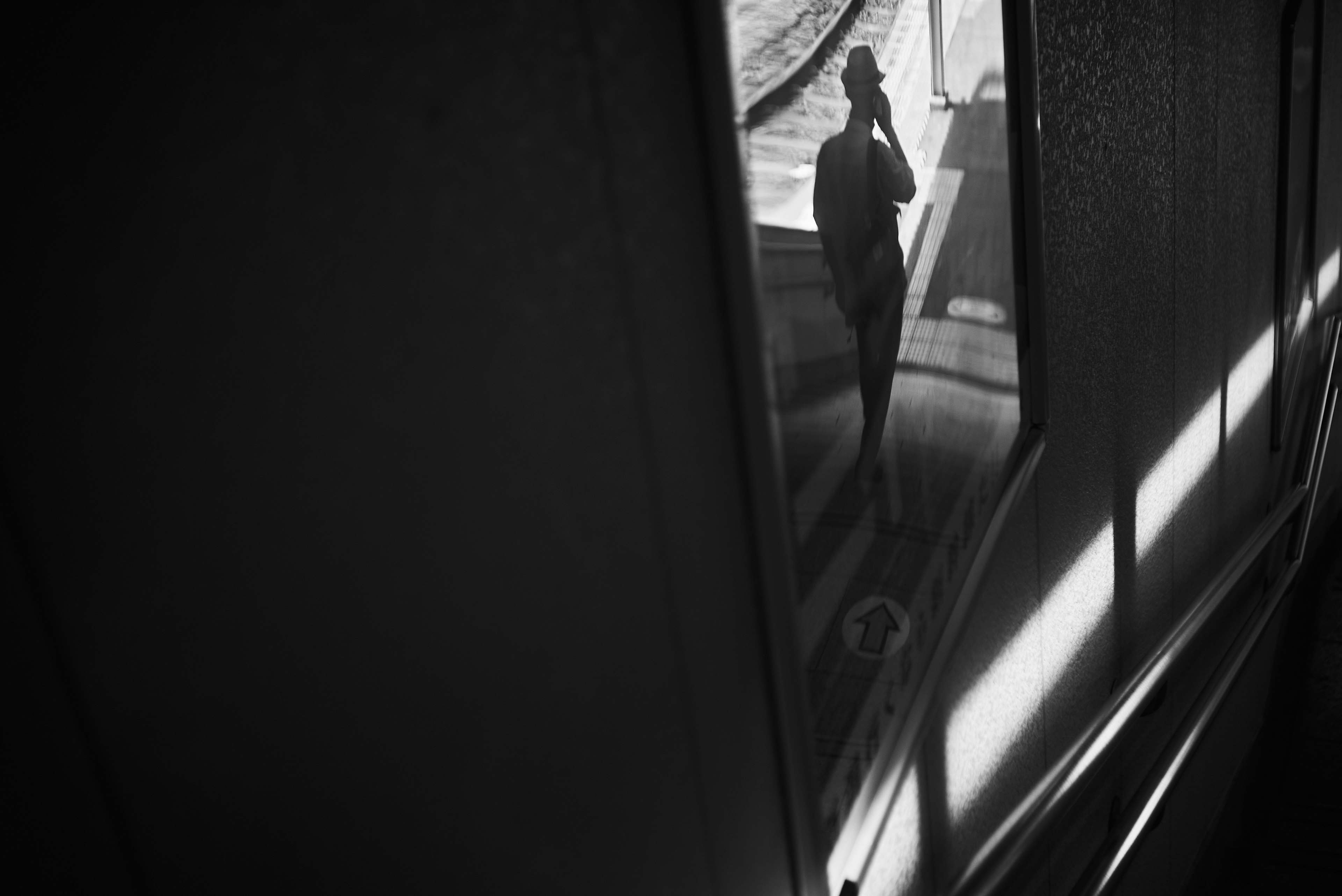 Silhouette of a person reflected in a window with contrasting light