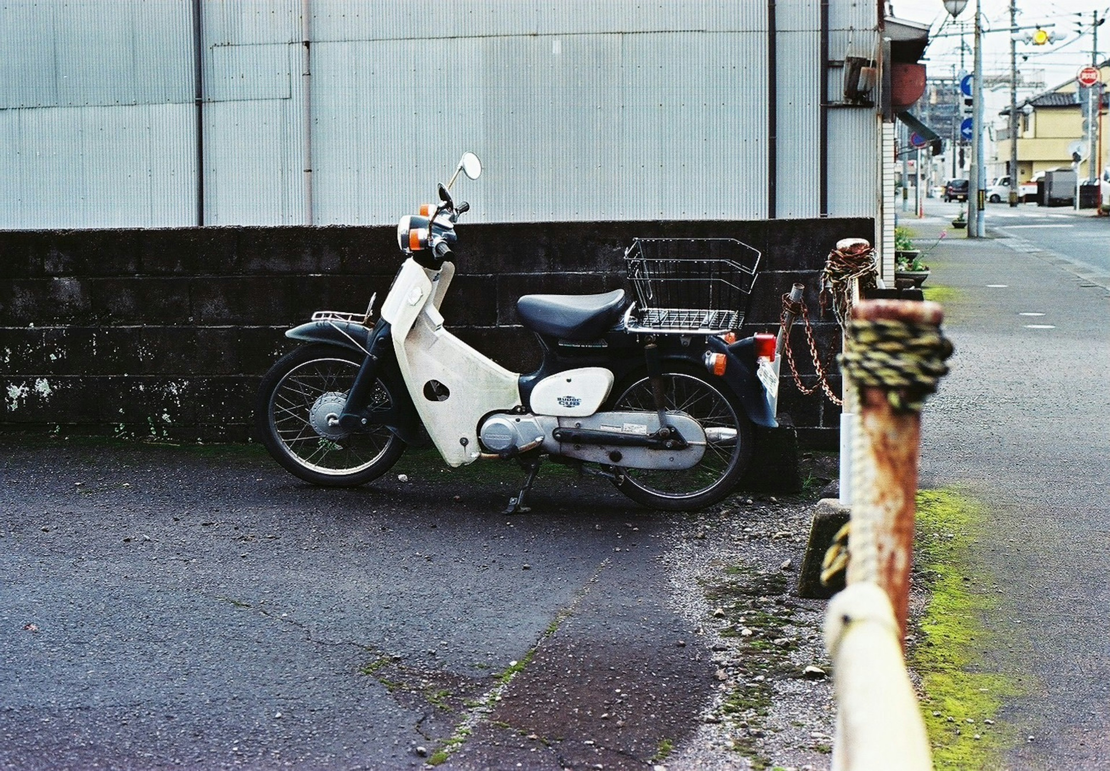 Ein schwarz-weißes Scooter, das neben einer Wand geparkt ist