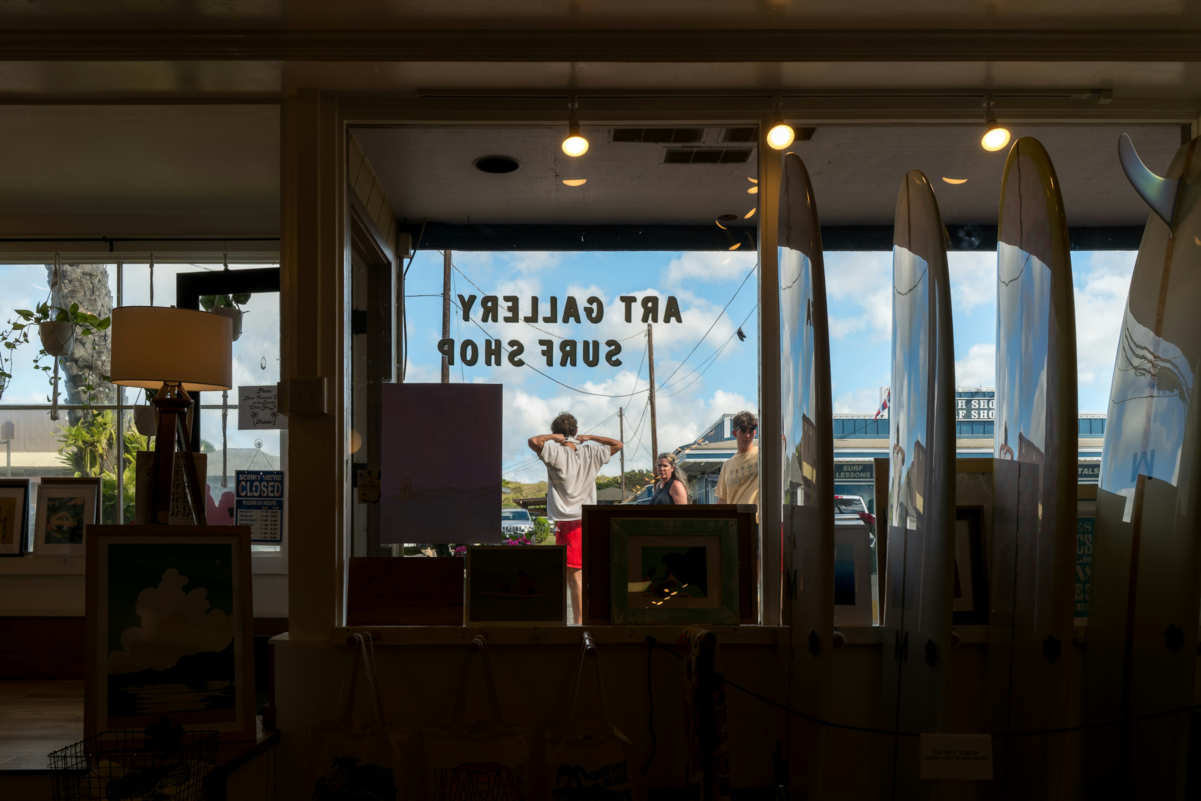 Blick auf das Innere einer Kunstgalerie durch ein Fenster mit Menschen draußen