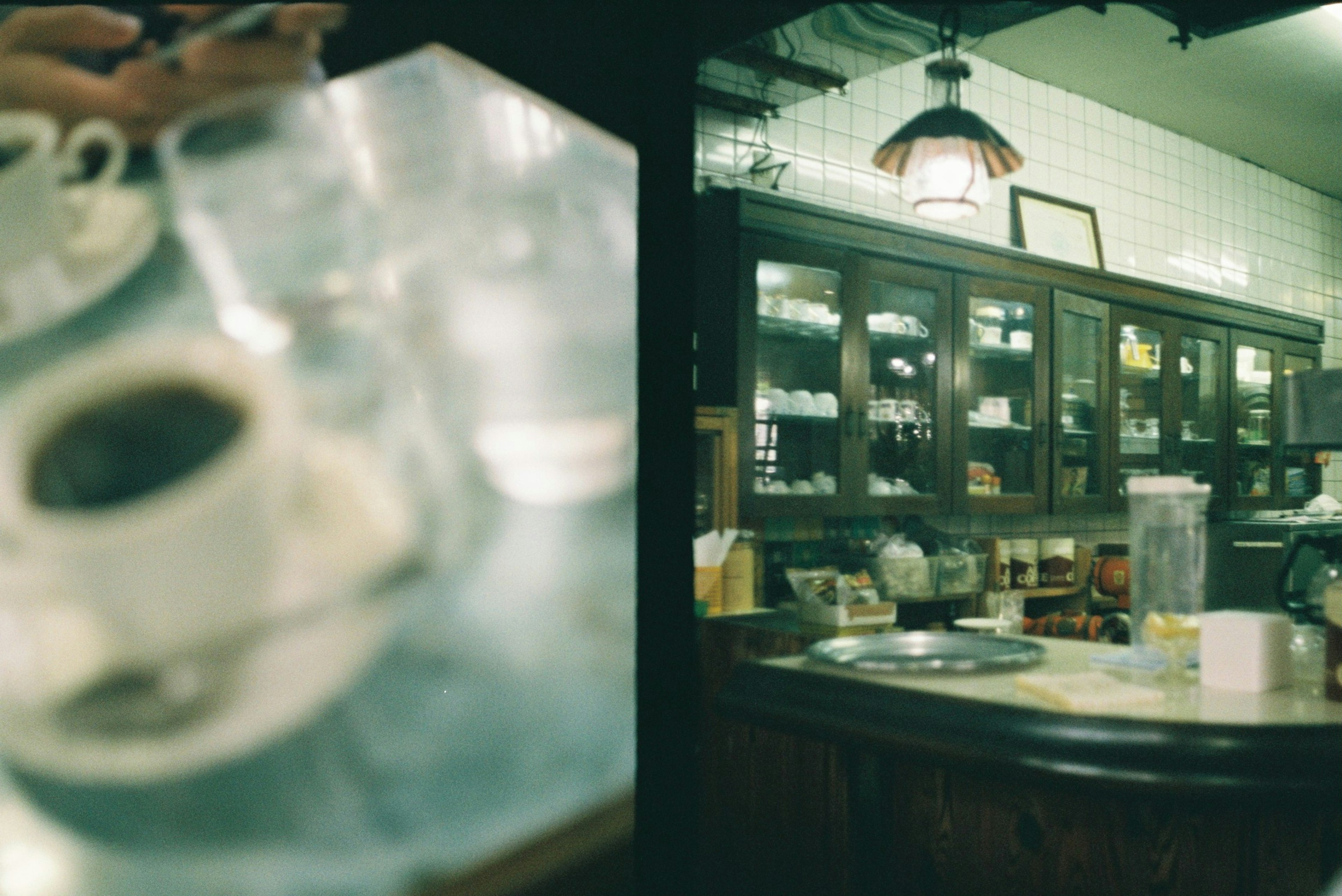 Immagine sfocata di tazze di caffè e un bancone con interni di caffè vintage