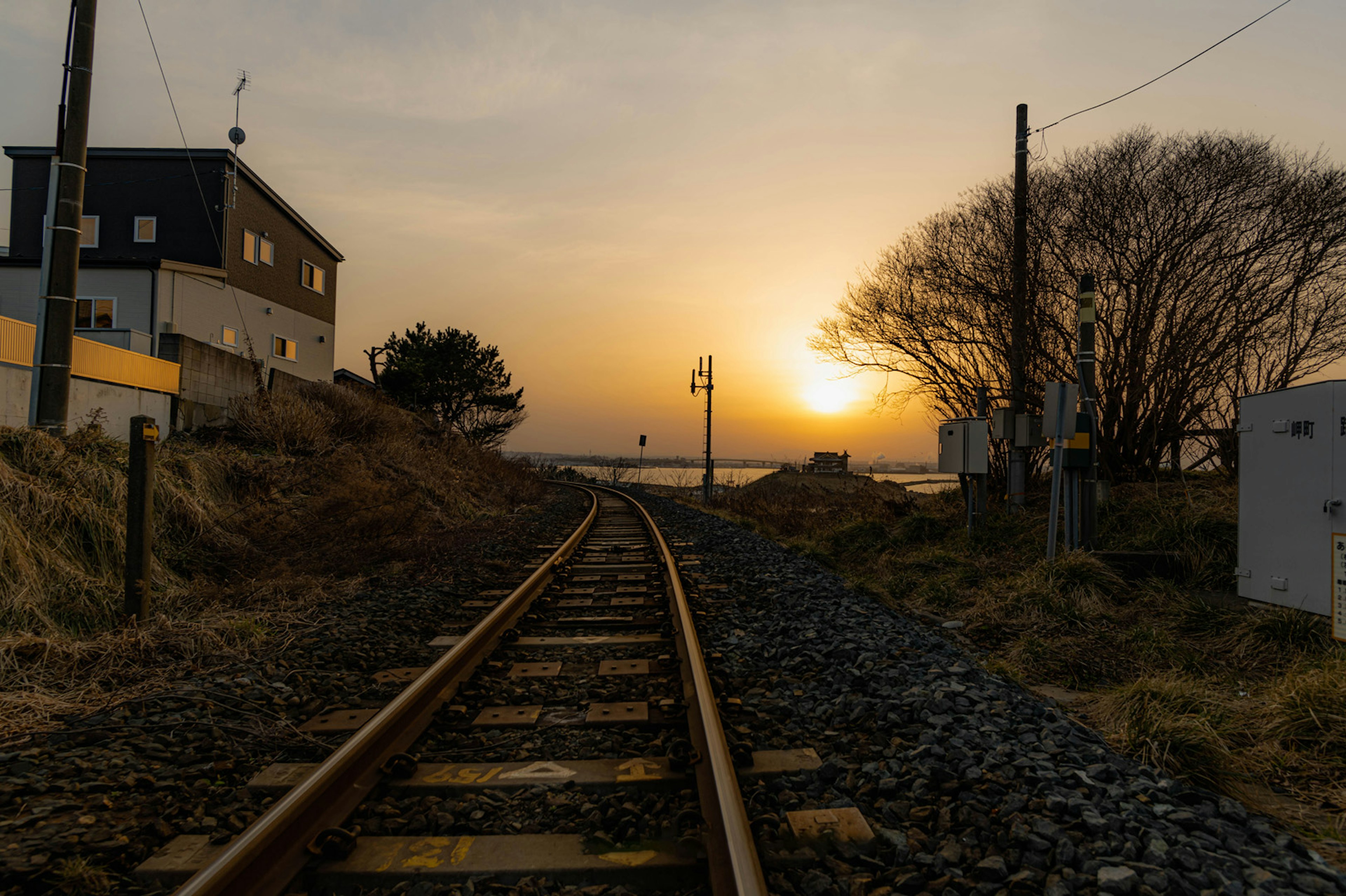 Voie ferrée au coucher du soleil avec paysage environnant