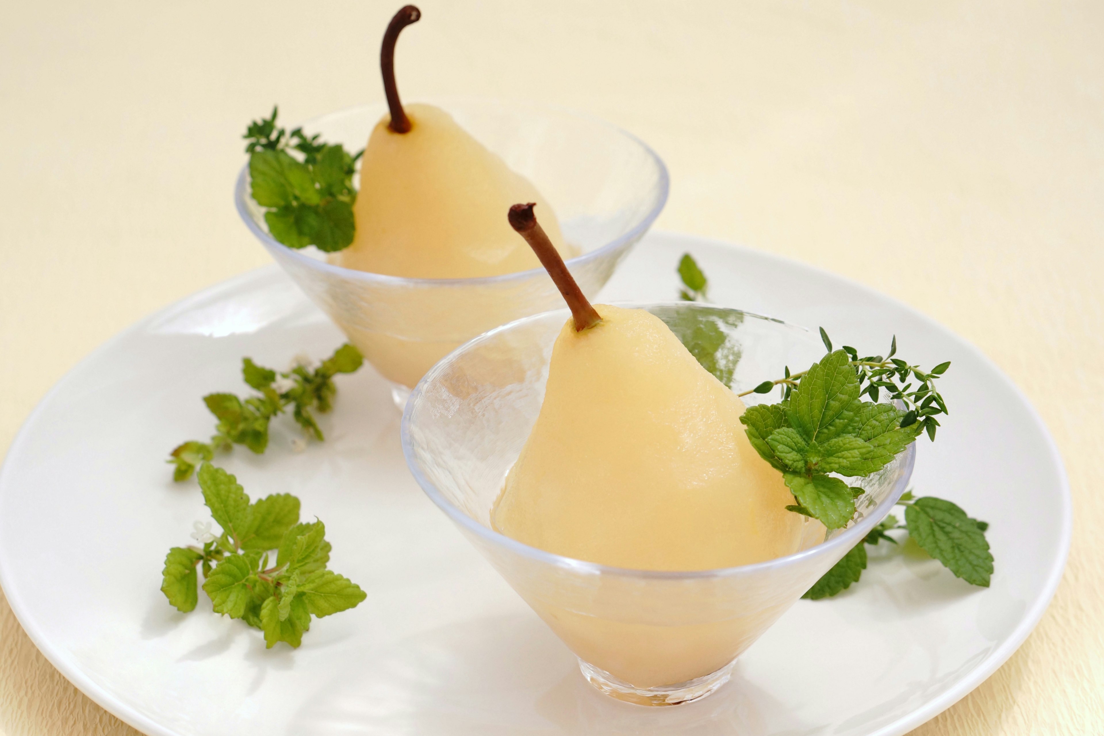 Pears in glass bowls garnished with mint leaves