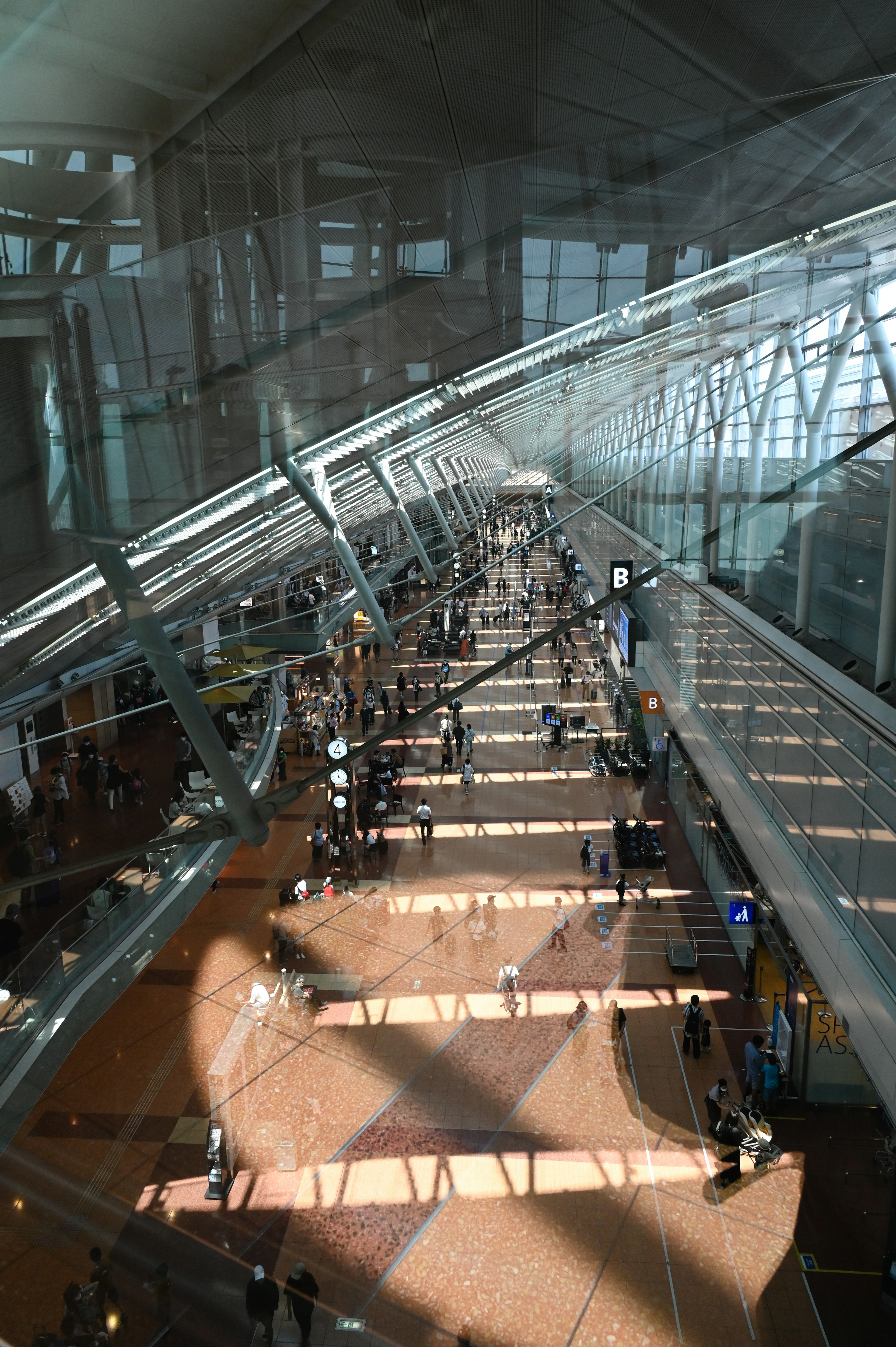 Interior brillante de un vestíbulo de aeropuerto con luz solar que entra a través de grandes ventanas y diseño moderno