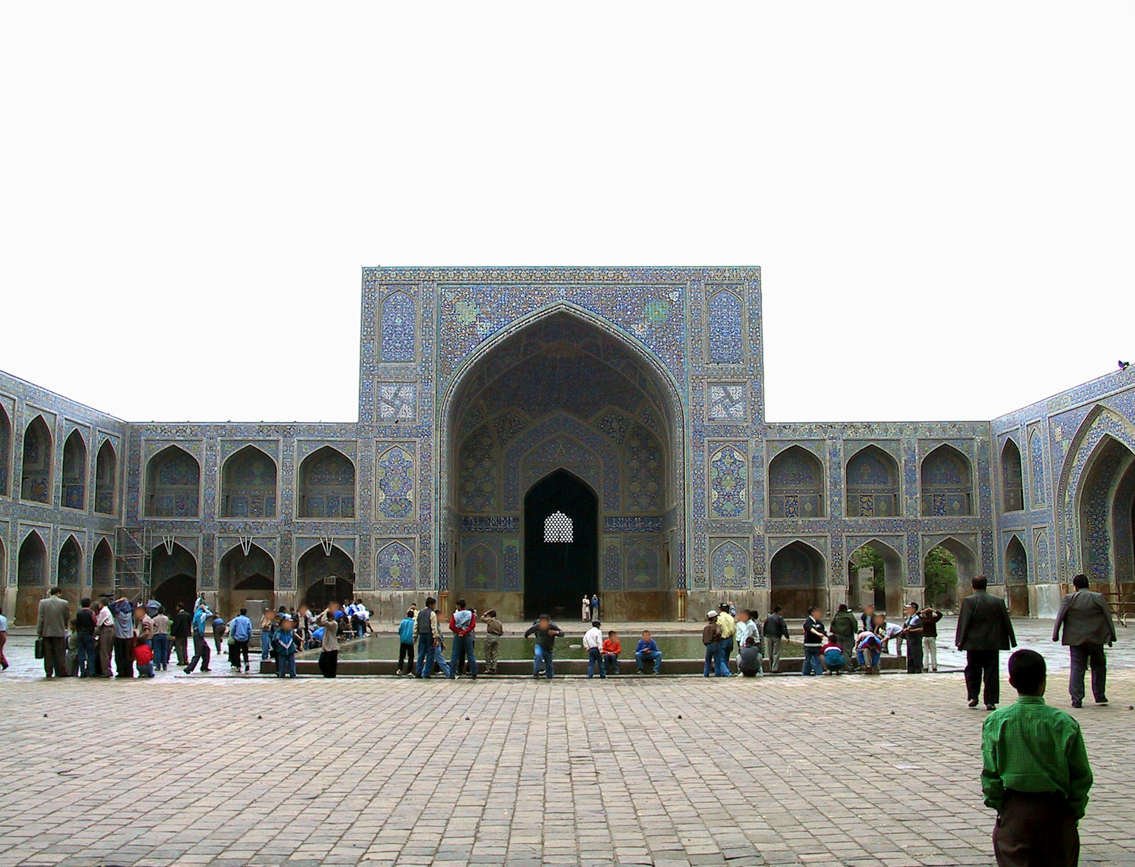 Tourists gathered in a courtyard with beautiful mosaic adorned architecture