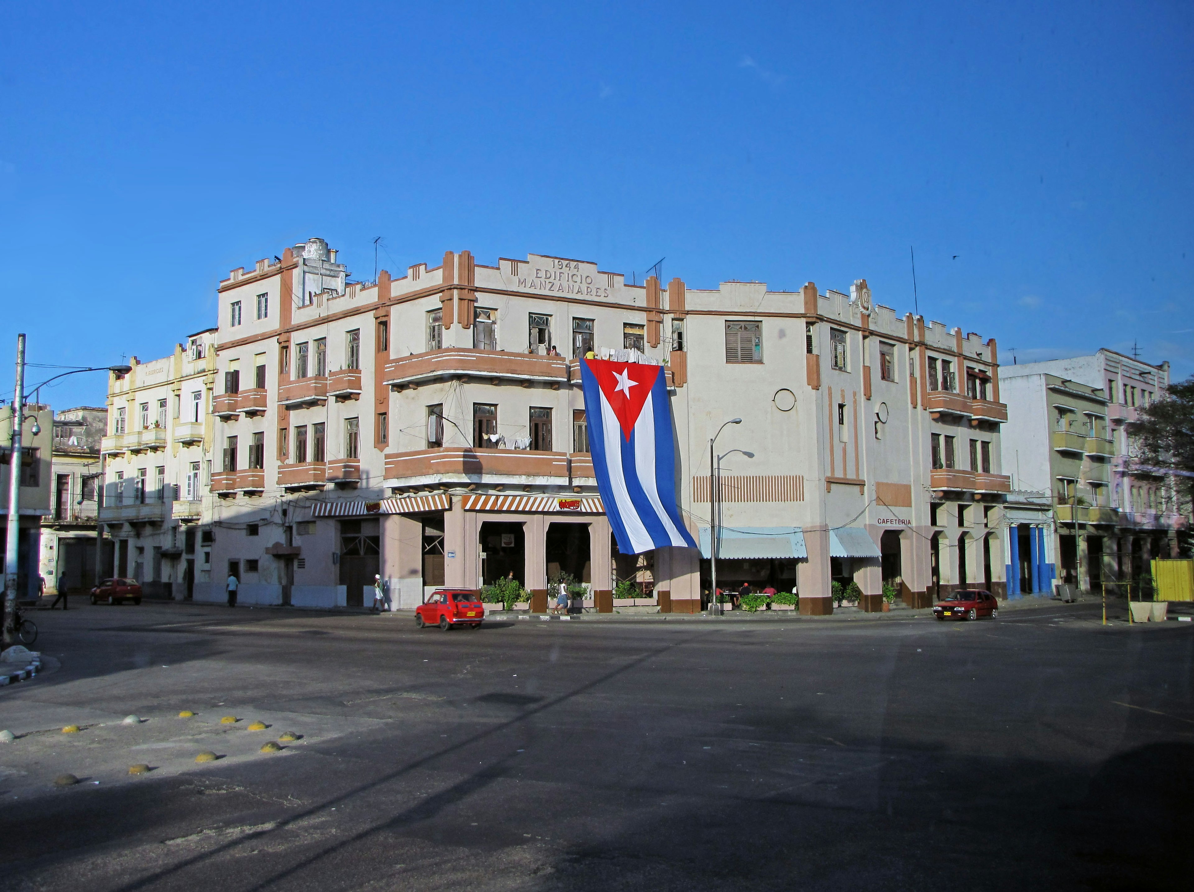 Intersection with a historic building featuring the Cuban flag