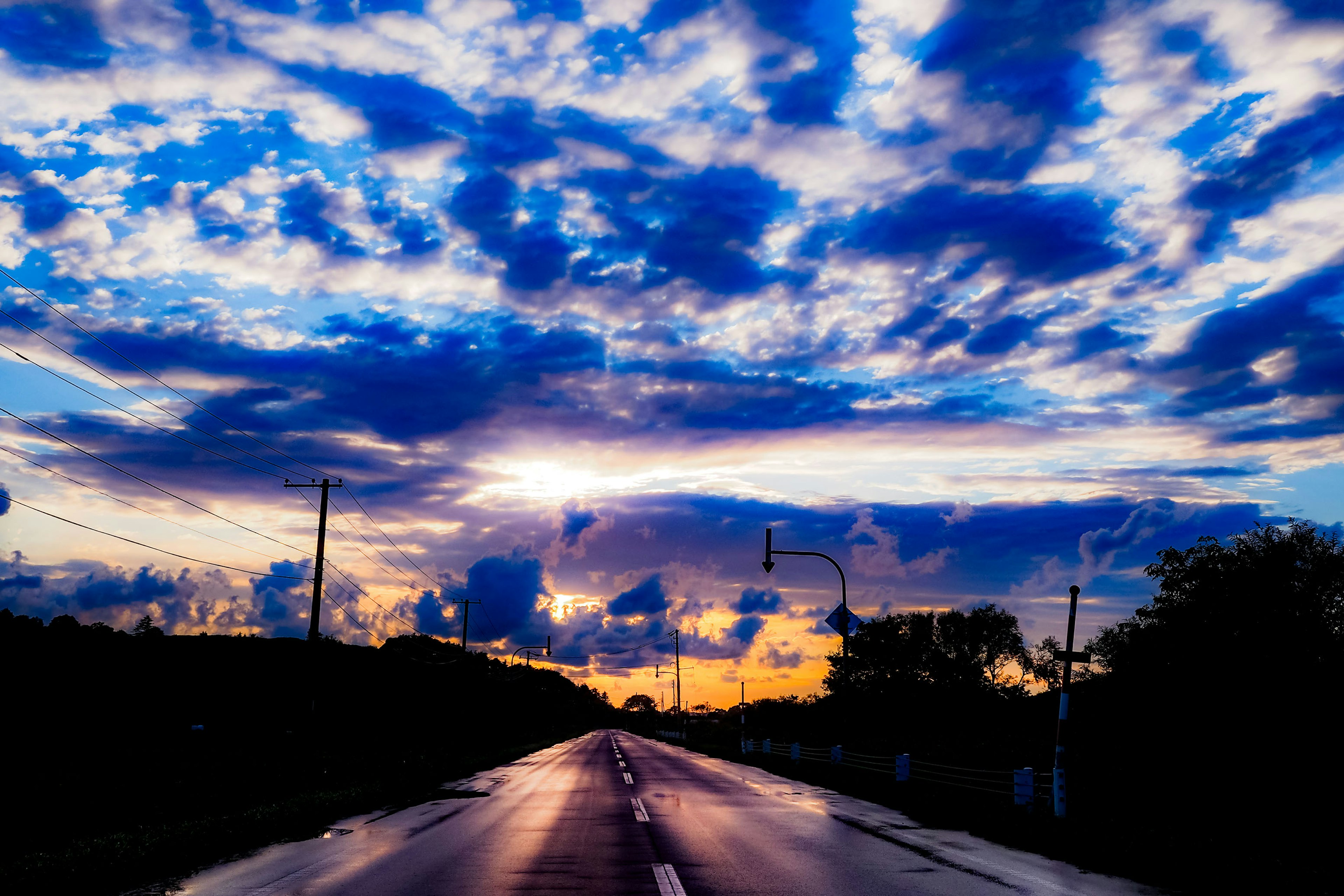 美しい夕焼けの空と反射する道路