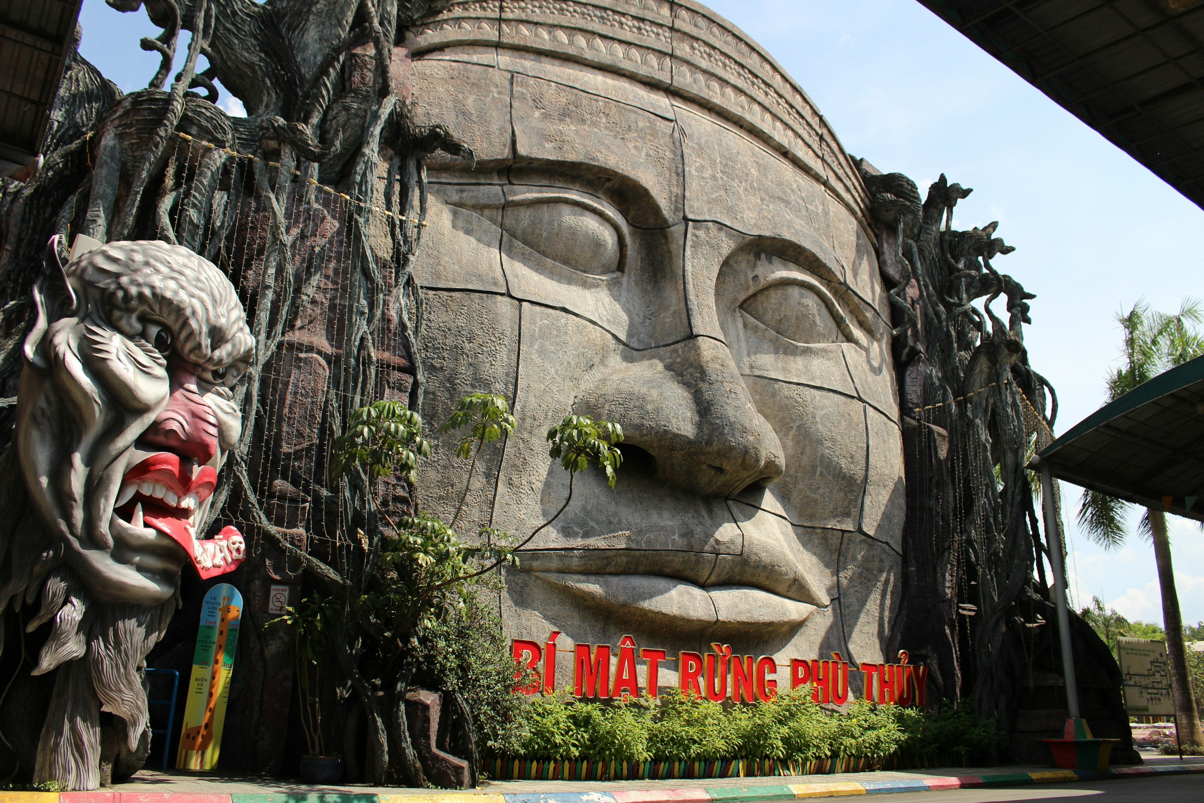 Entrada de un parque temático con una gran escultura de cara