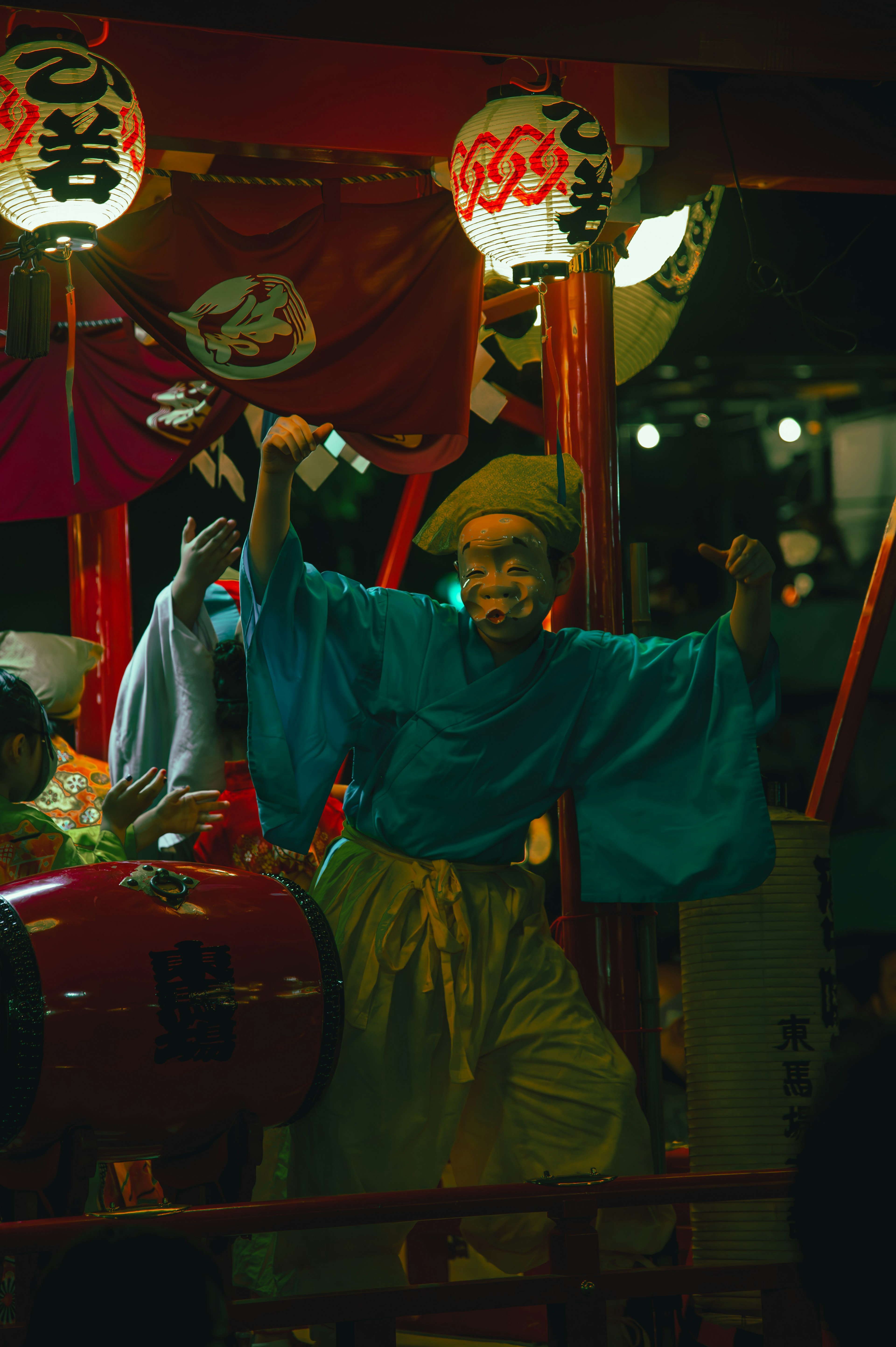 青い衣装の踊り手が祭りで演舞している様子