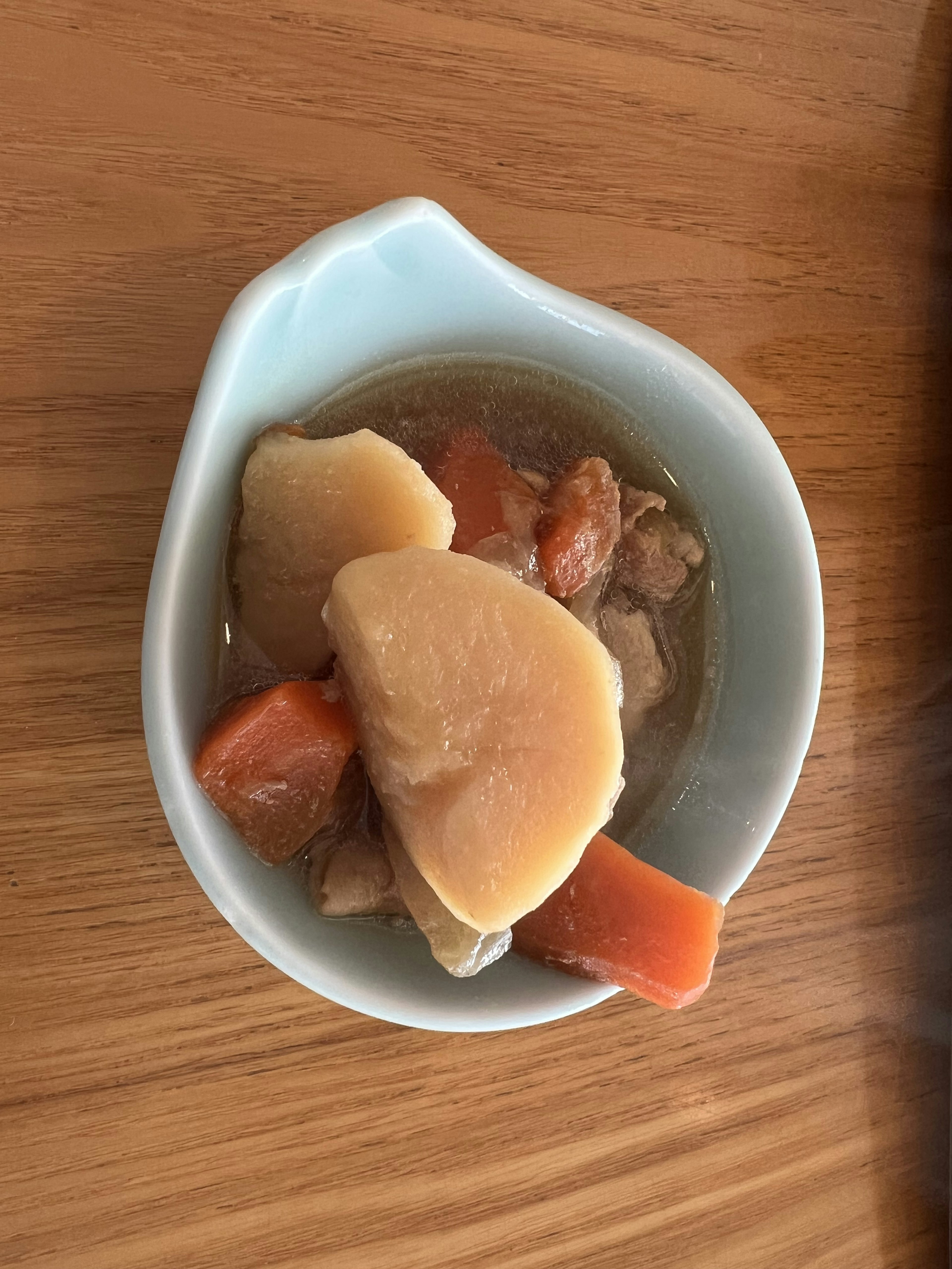 青い皿に盛り付けられた野菜と肉の煮物