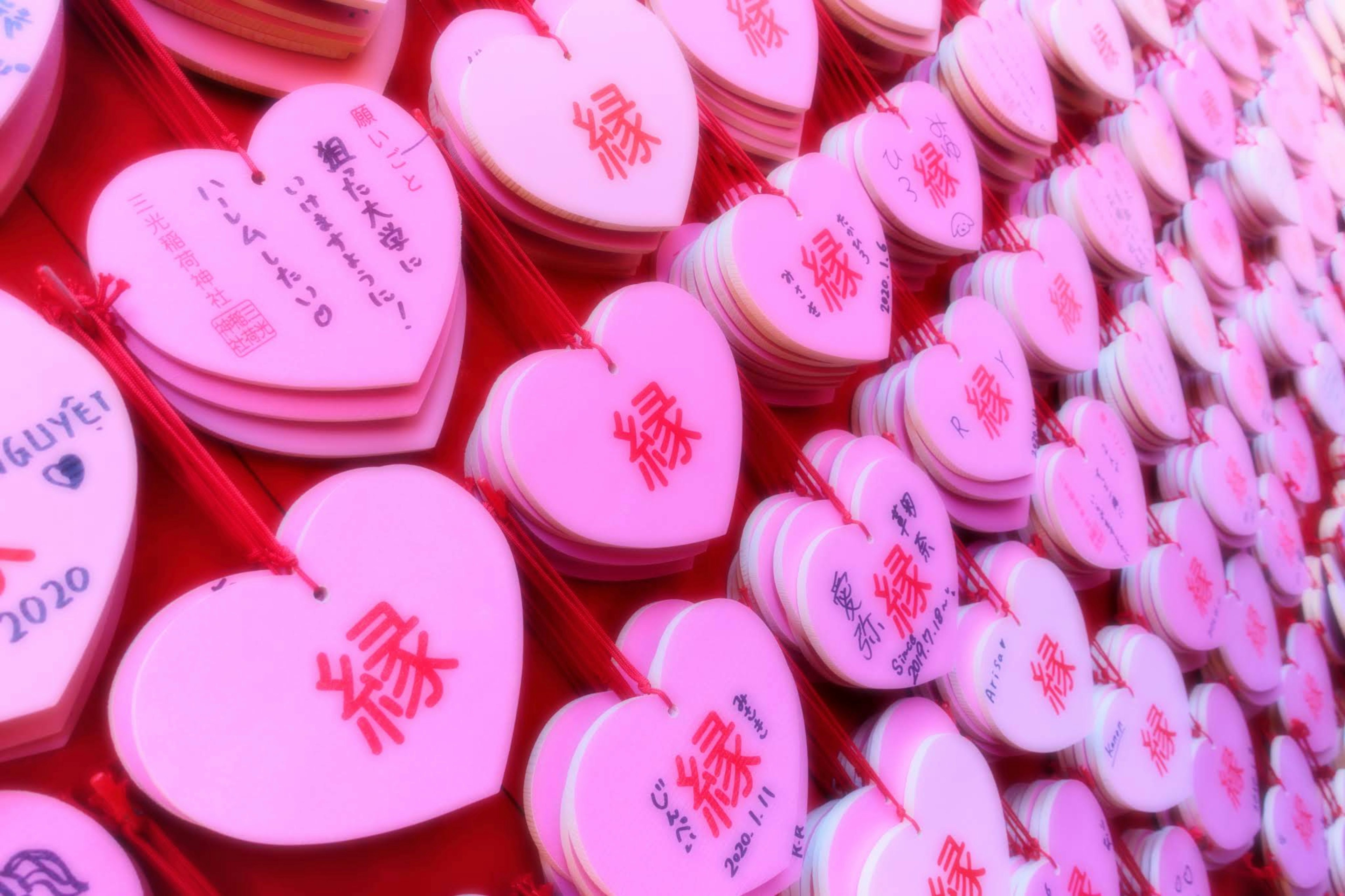 A vibrant display of pink heart-shaped decorations arranged in rows