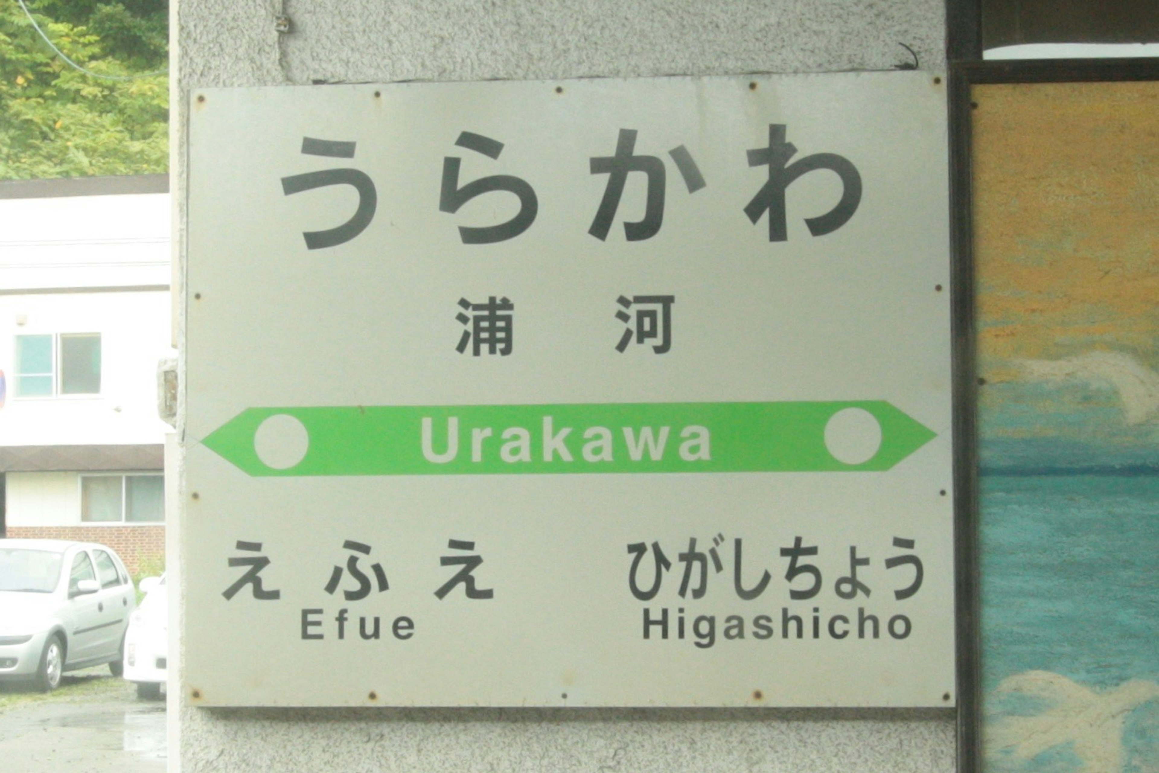 Station sign for Urakawa with green arrows indicating directions