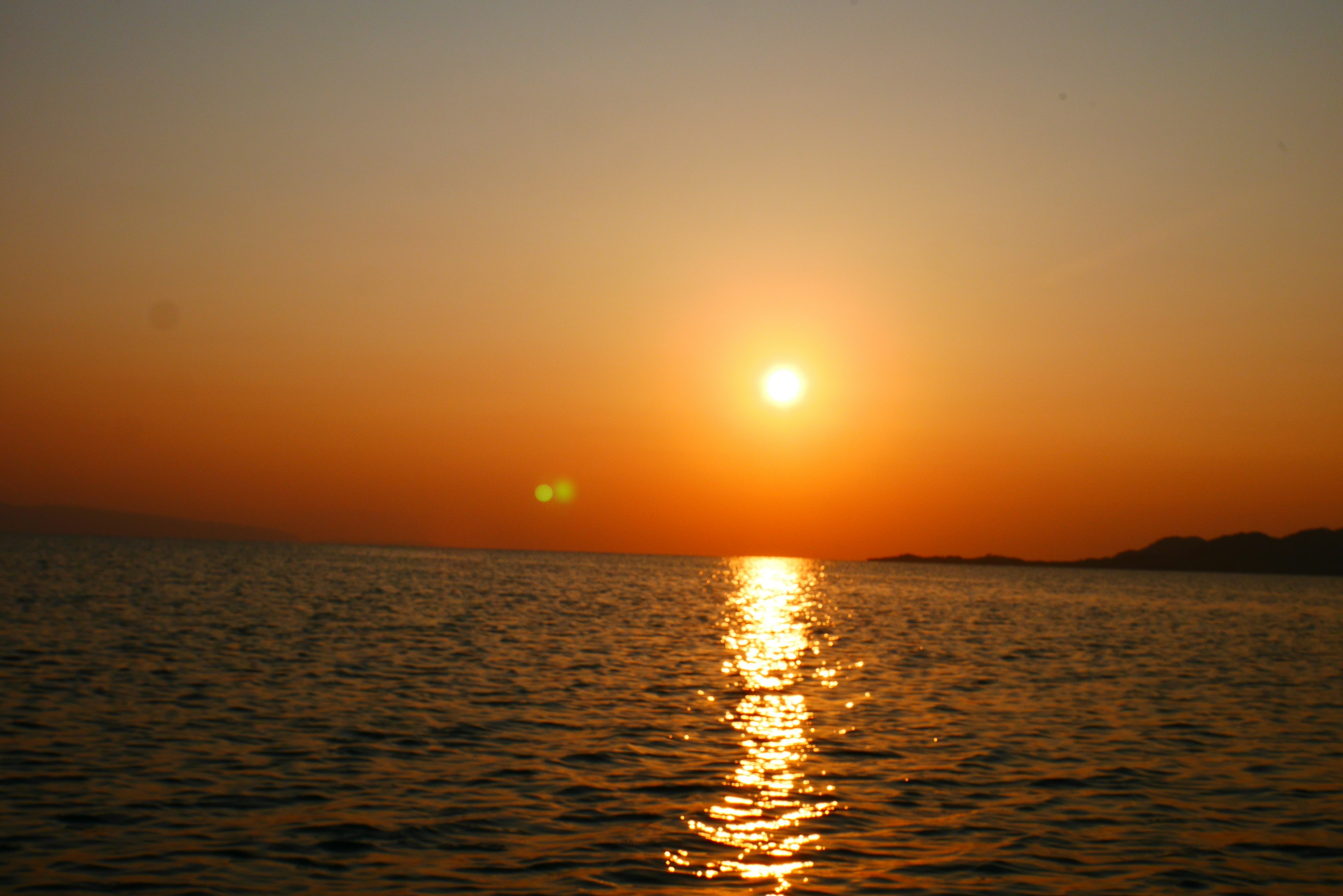 Atardecer sobre el océano con cielo naranja