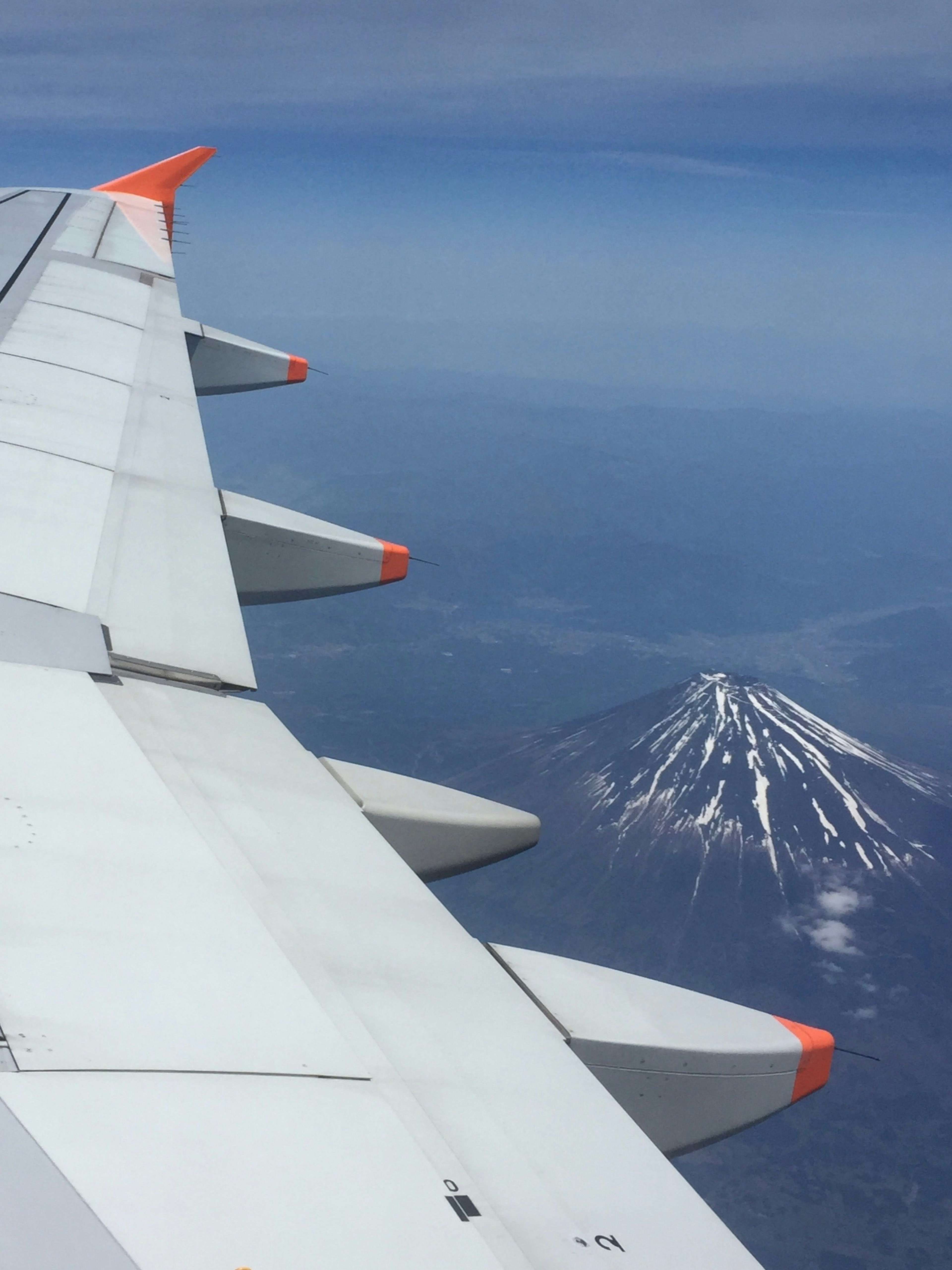 Airplane wing with a view of a snow-capped mountain