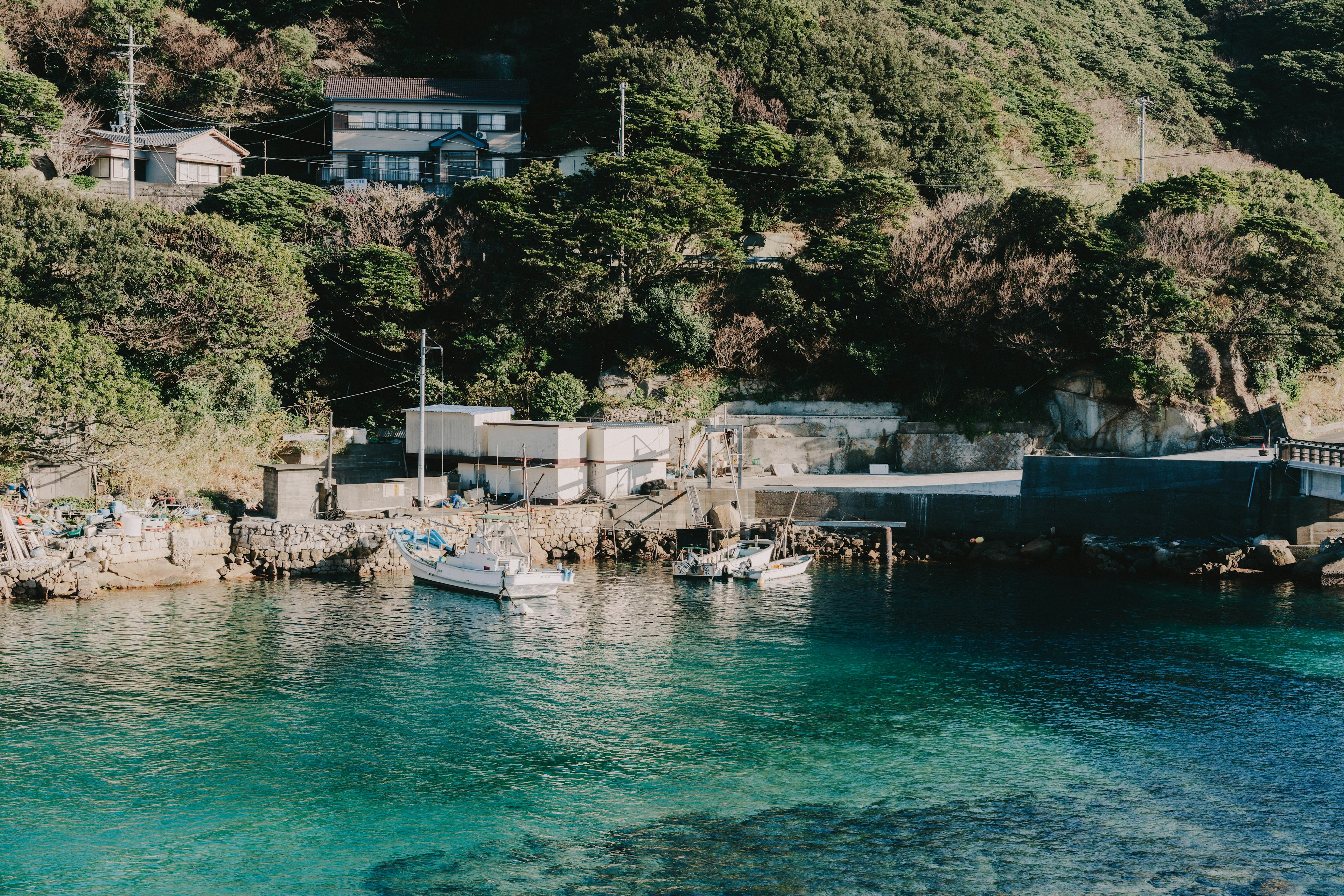 Scenic coastal view featuring clear turquoise water and small boats