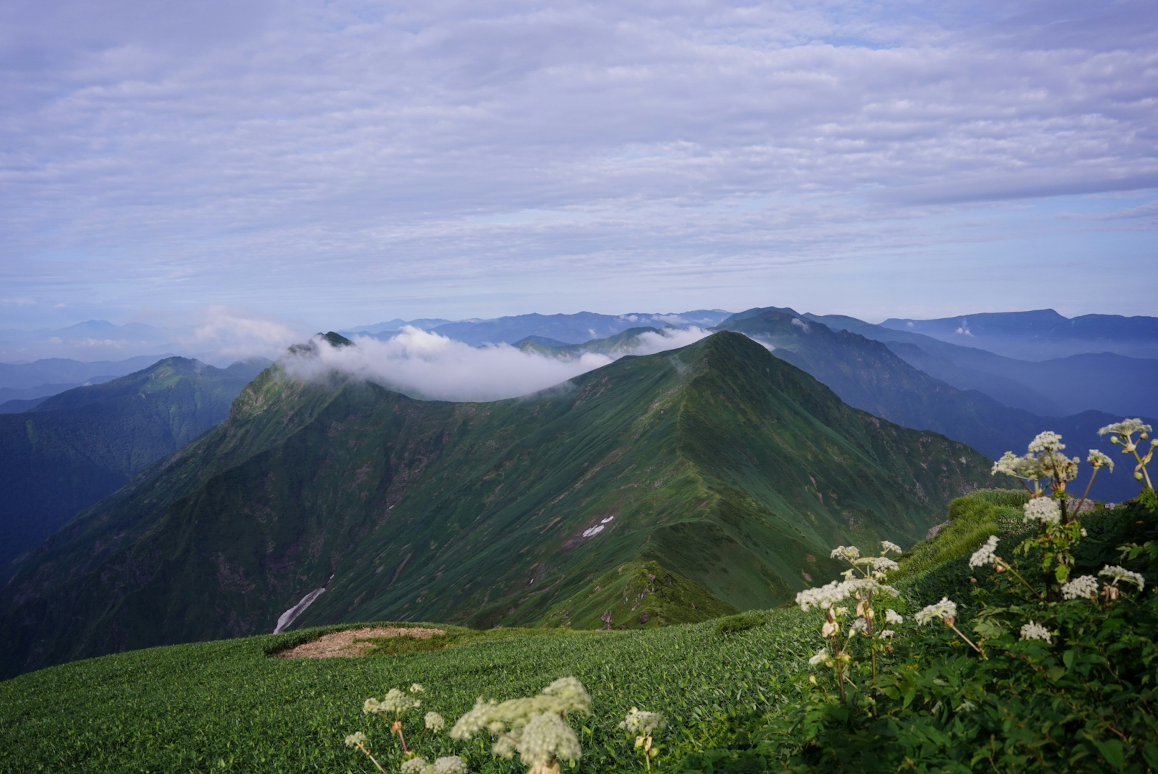 緑豊かな山々と雲に覆われた山頂の風景