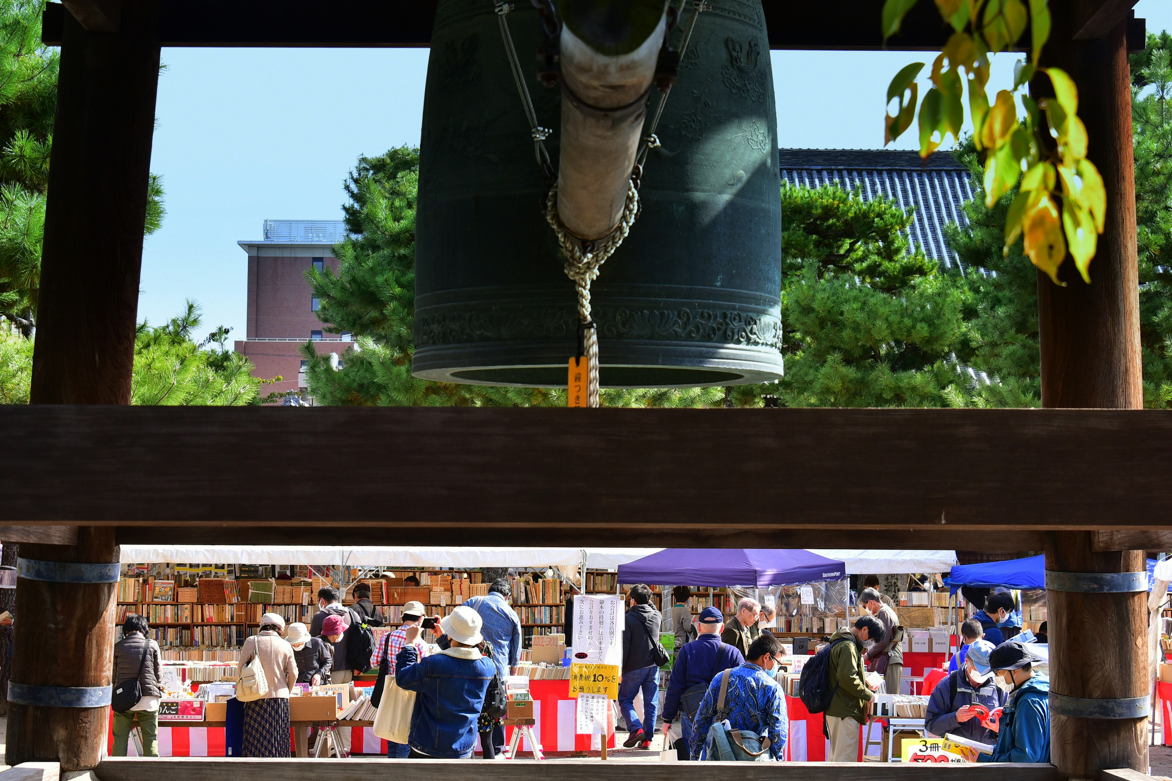 View of a bustling market scene under a large bell