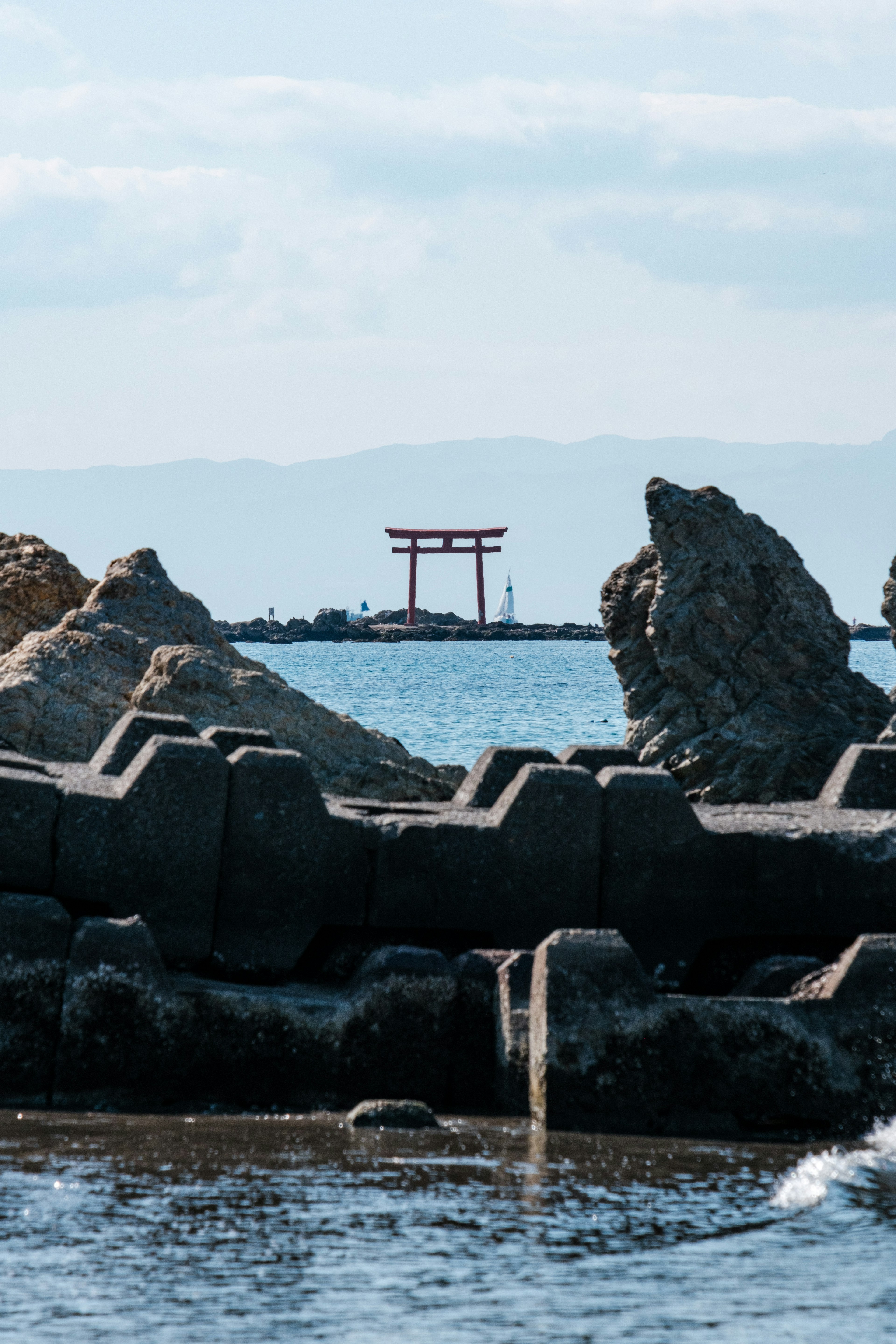 Scenic view of a torii gate and rocky coastline