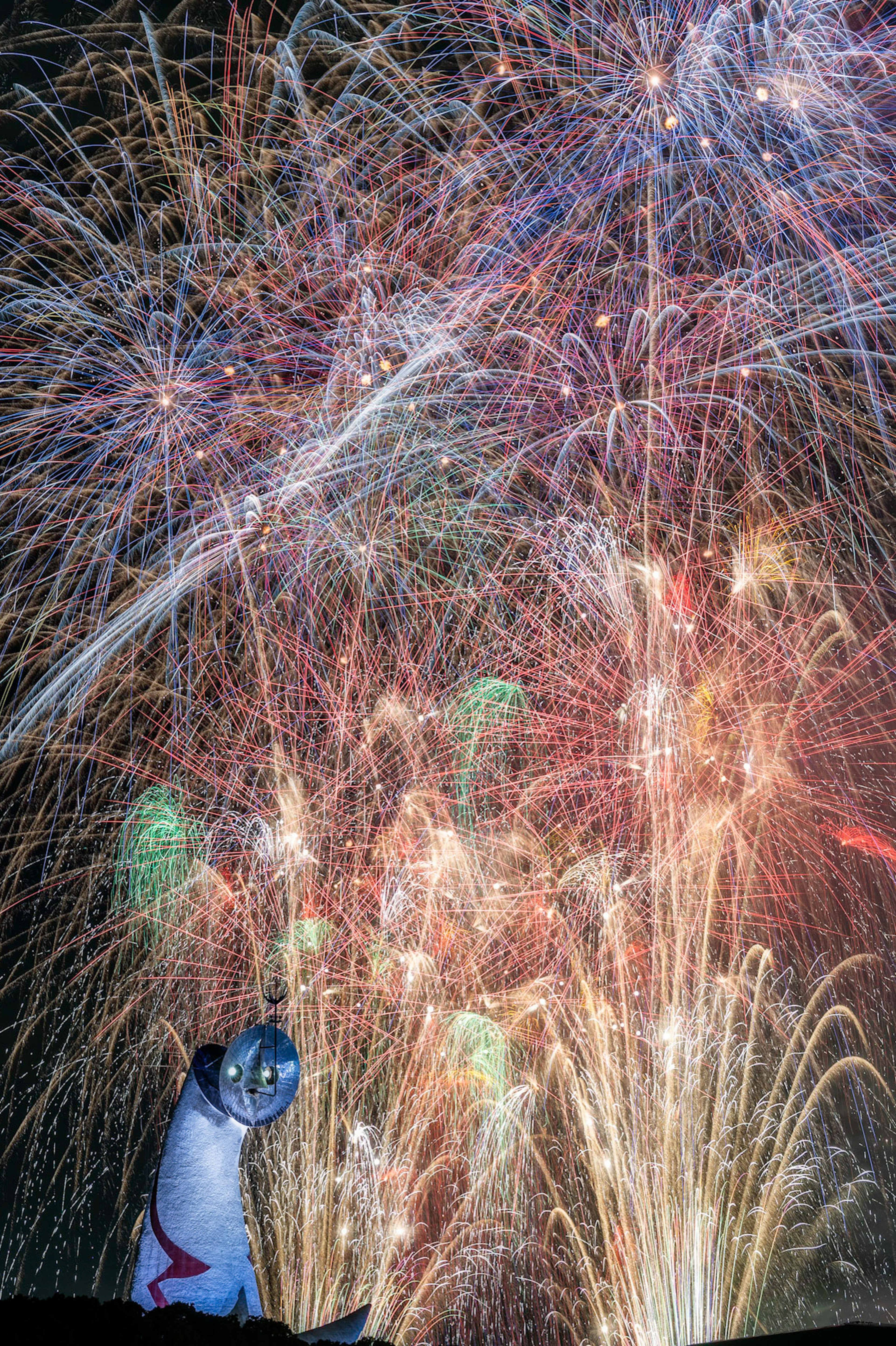 Eine Fischstatue vor einem farbenfrohen Feuerwerk