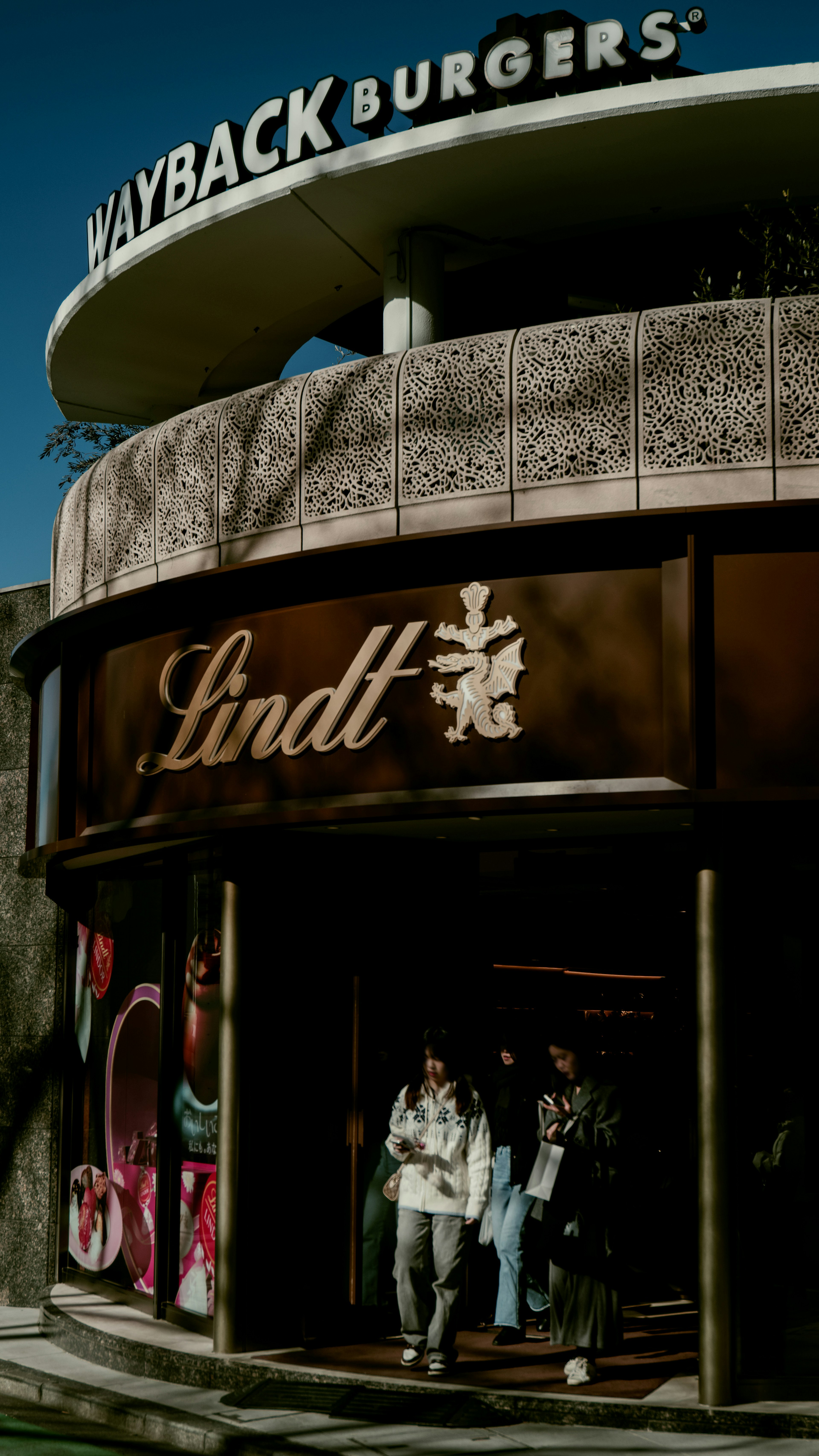 Façade de Wayback Burgers avec l'entrée du magasin Lindt visible