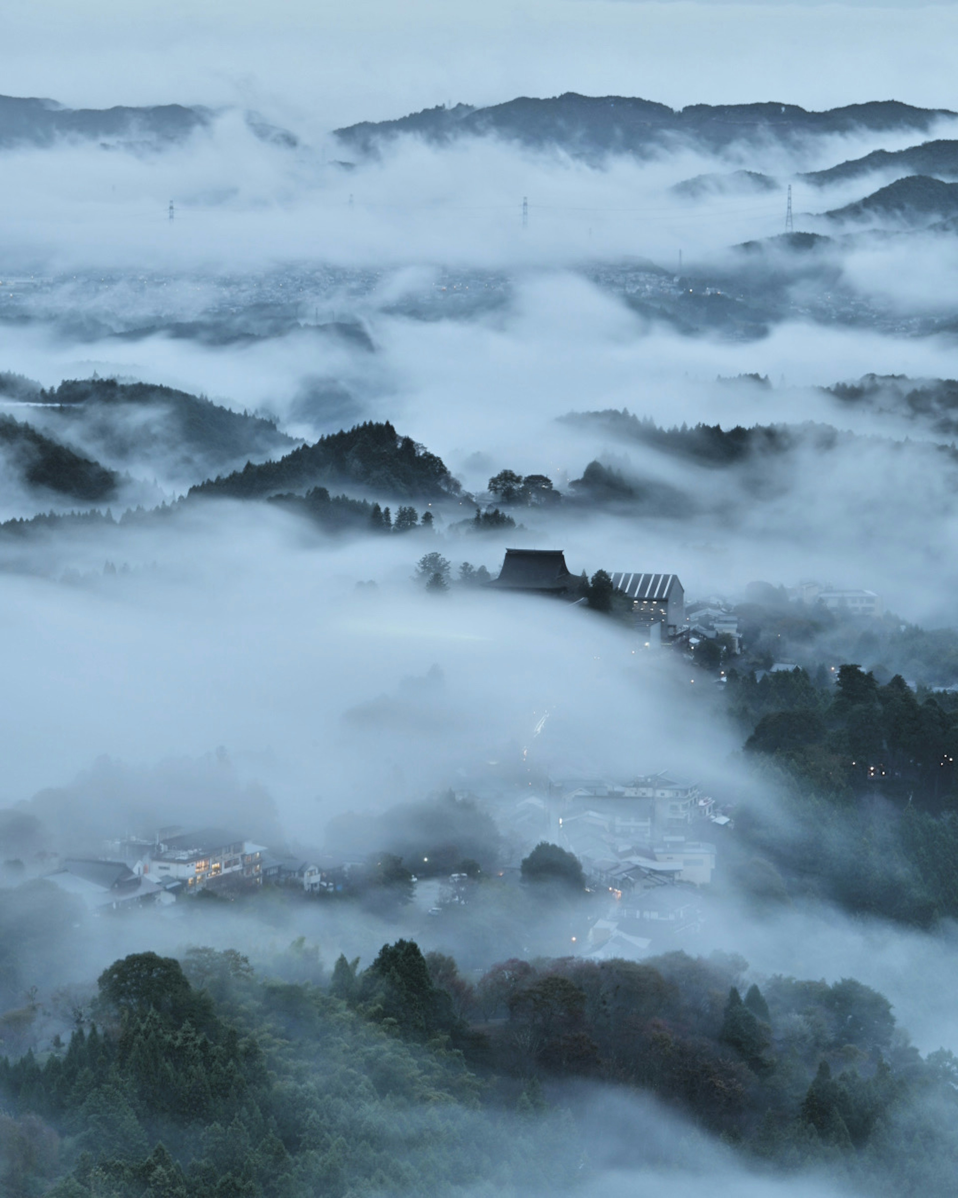 Paysage serein de montagnes et de village enveloppé dans le brouillard