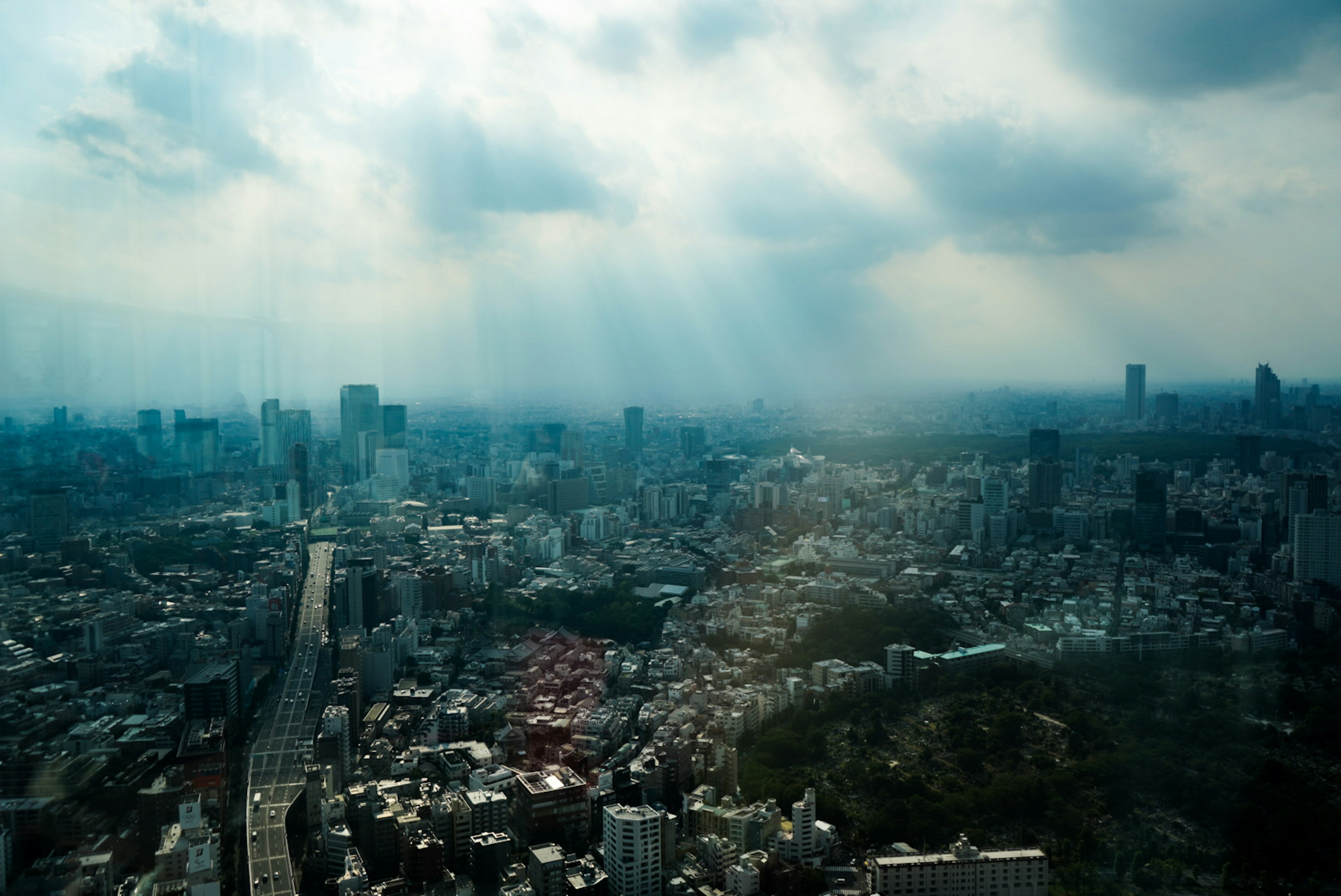 高層ビルと雲が広がる都市の景色と光のビーム