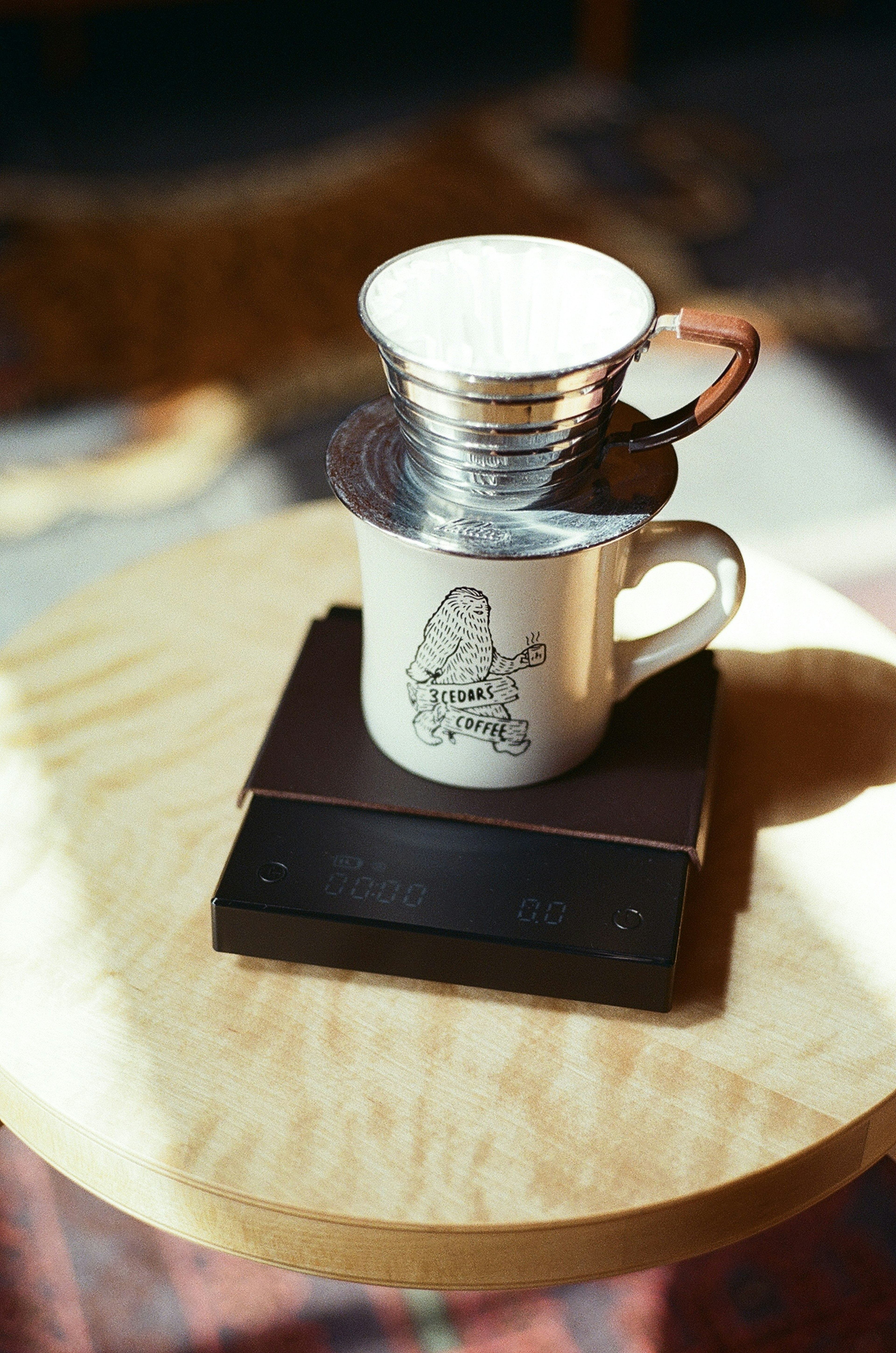 Image showing a coffee brewing setup with a white mug and a metal dripper on a wooden surface