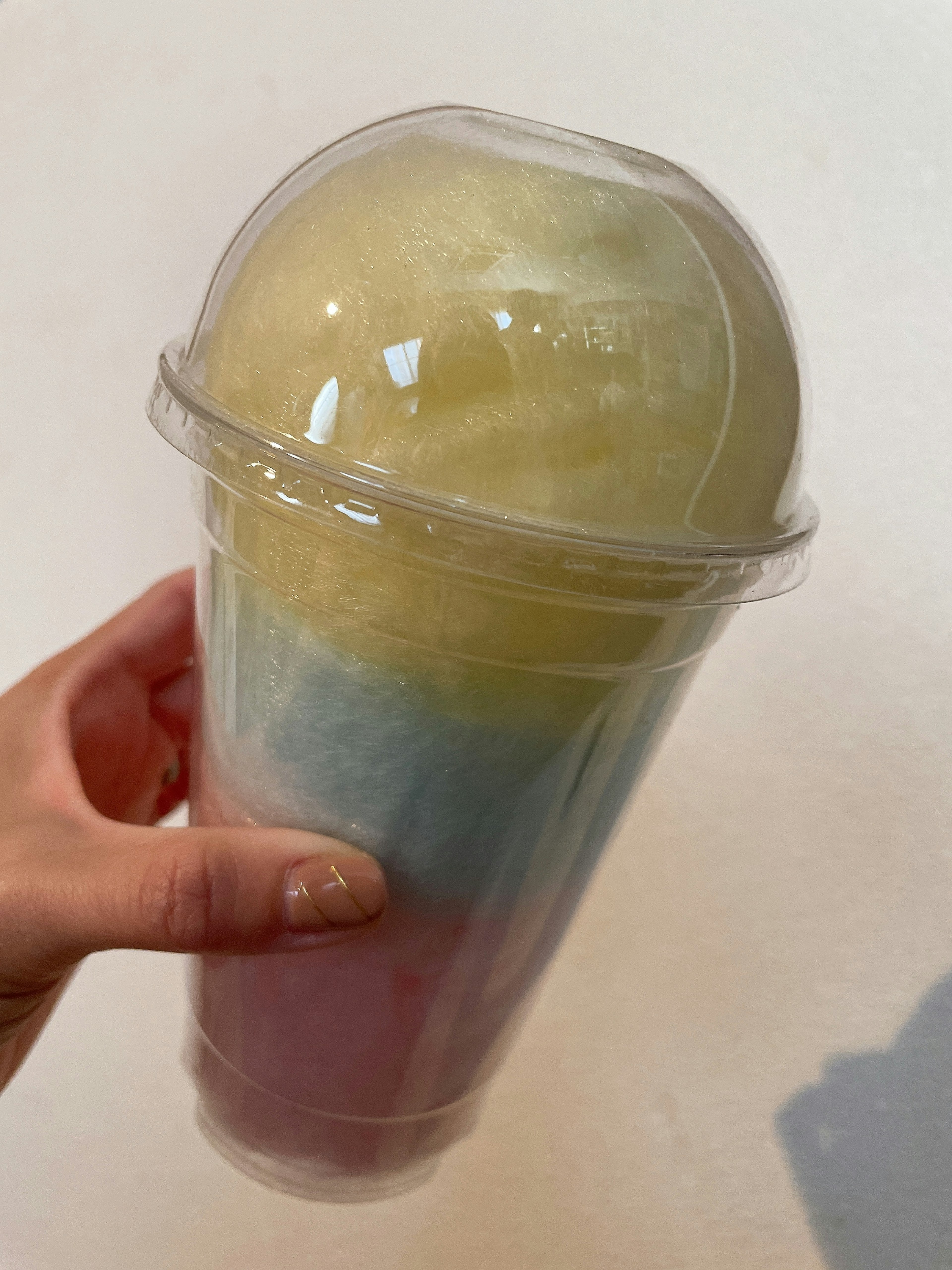 A colorful shaved ice dessert held in a hand