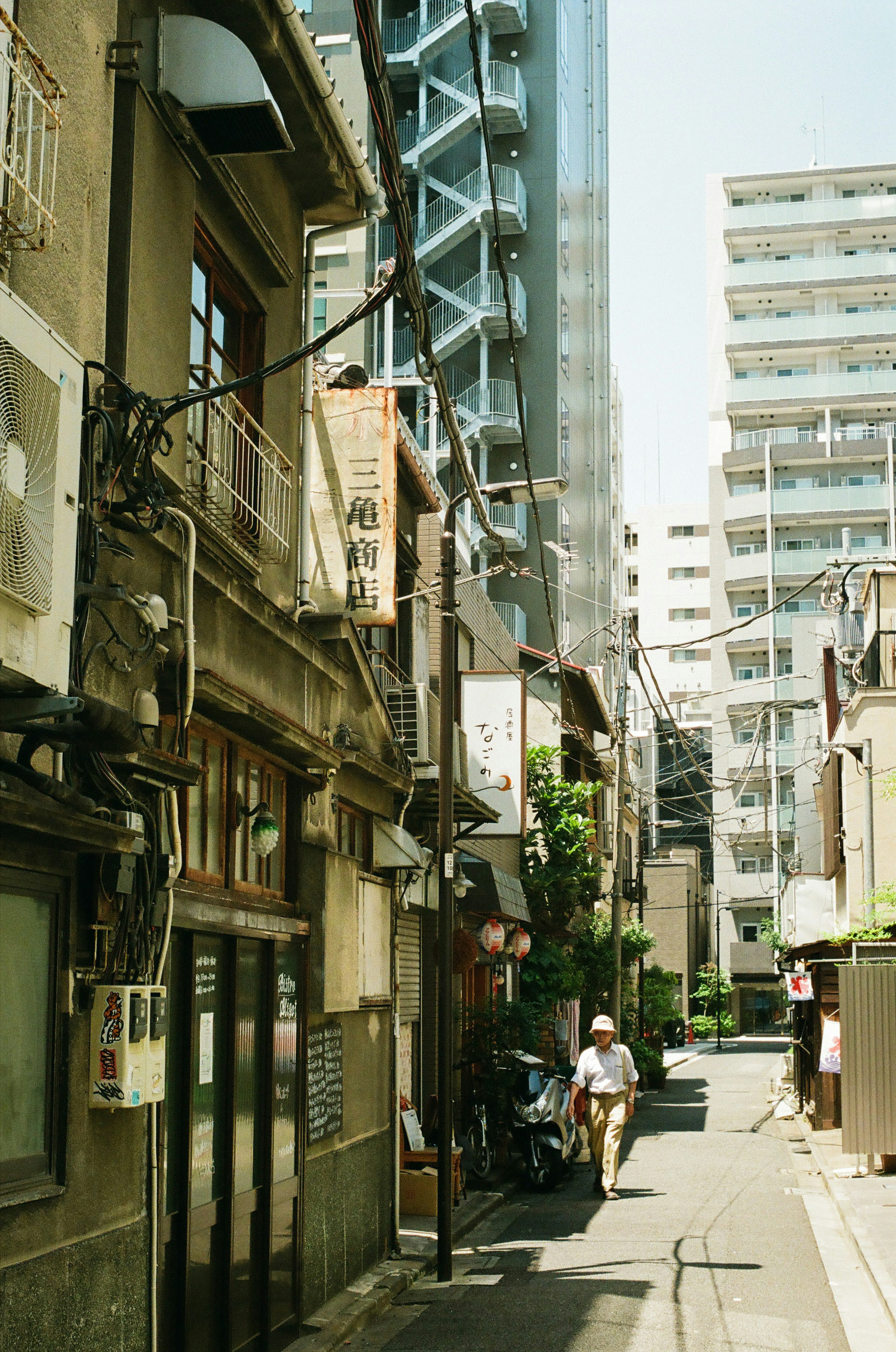 Narrow alley featuring old buildings alongside modern skyscrapers