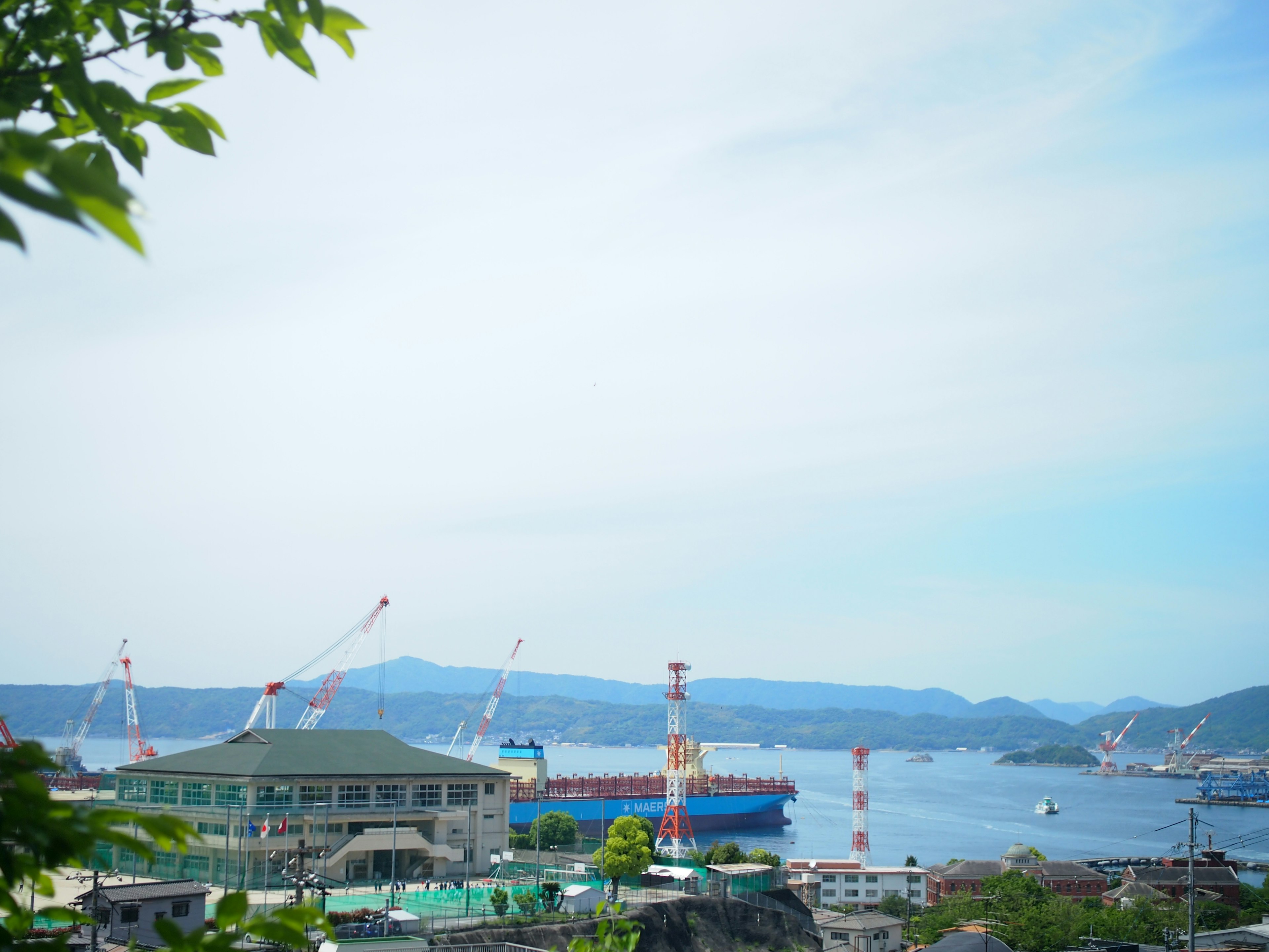 Pemandangan pelabuhan dengan langit biru dan derek di kapal