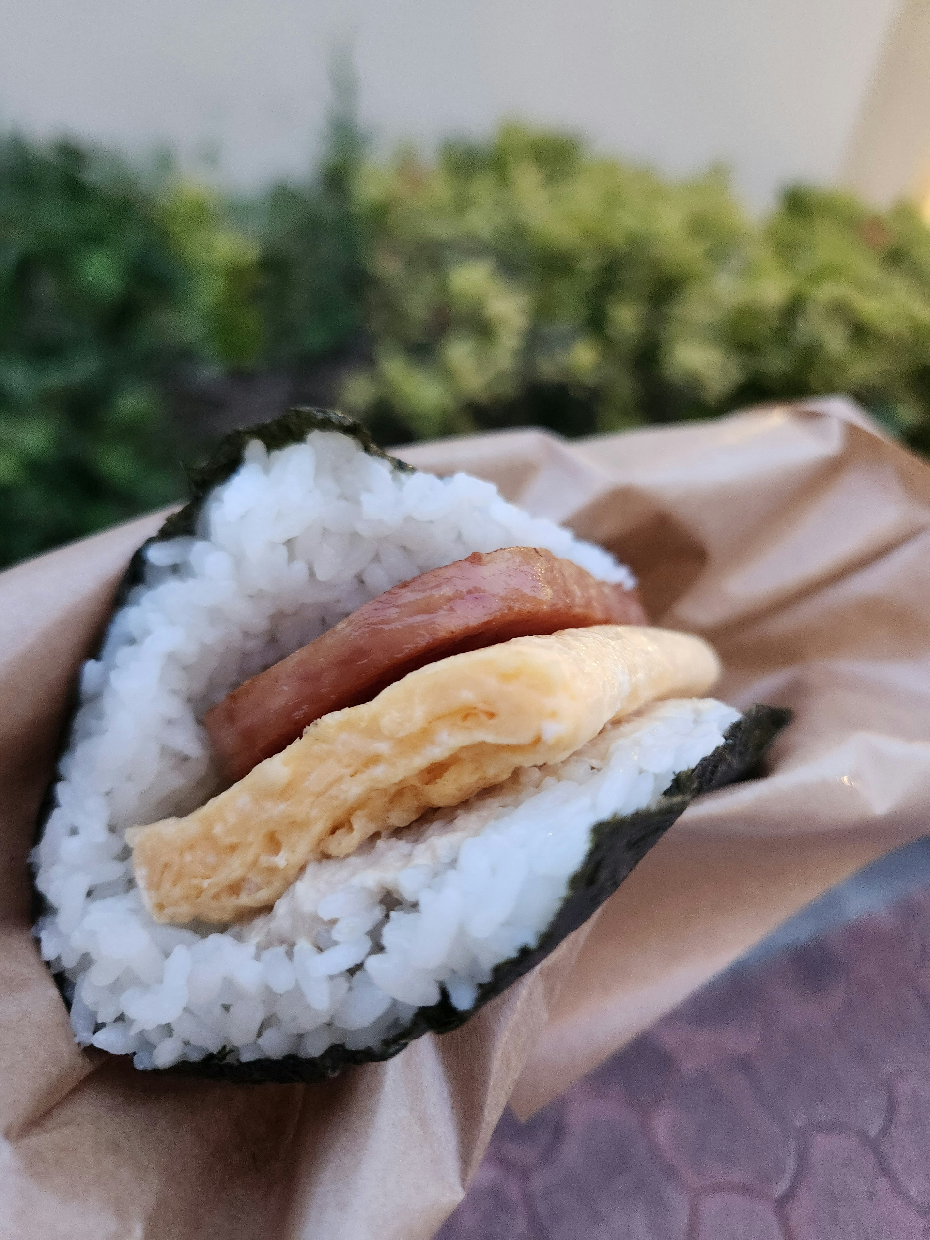 Onigiri wrapped in seaweed with a filling of omelette and ham