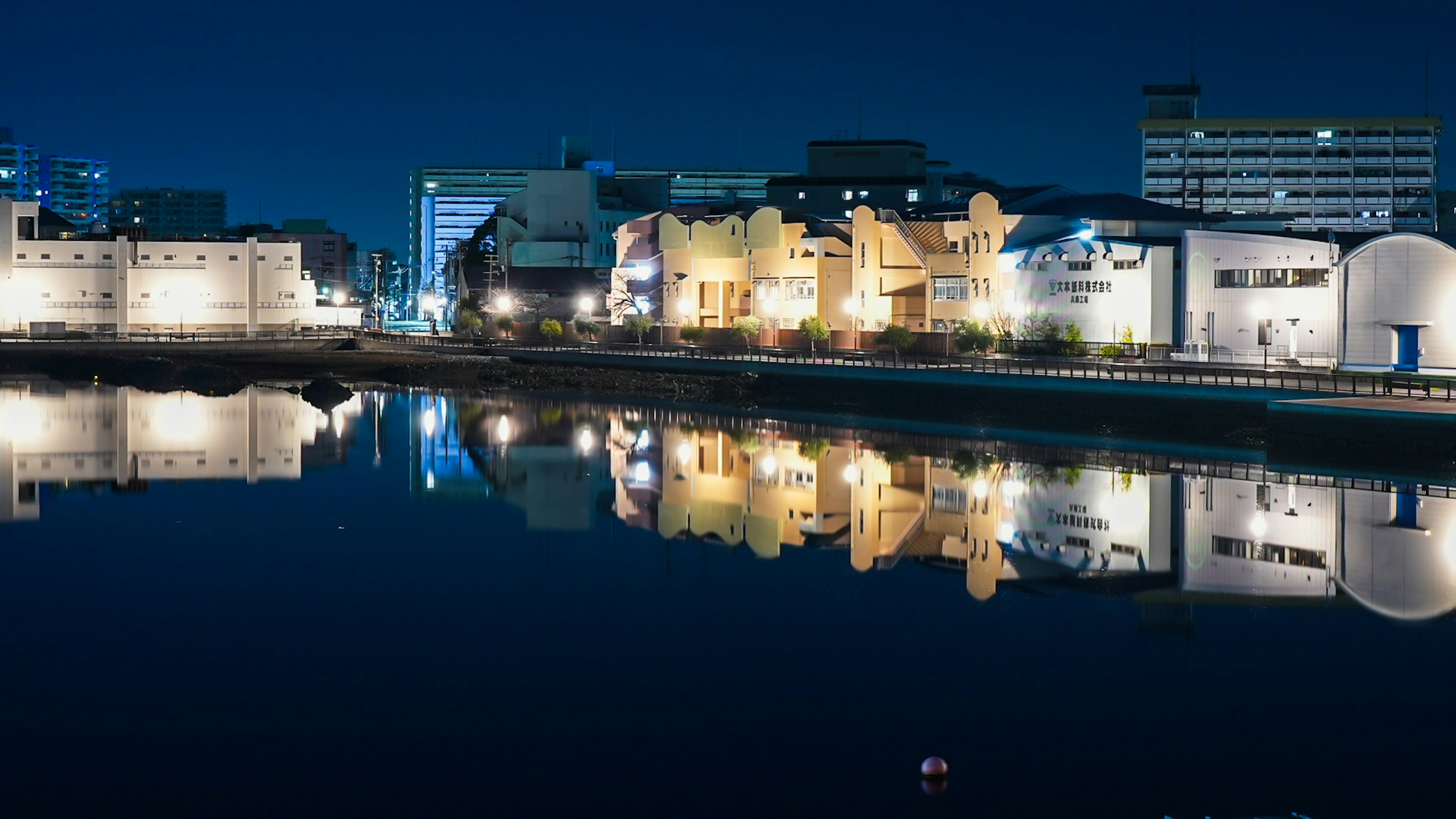 Hermosa reflexión de los edificios a lo largo del río por la noche